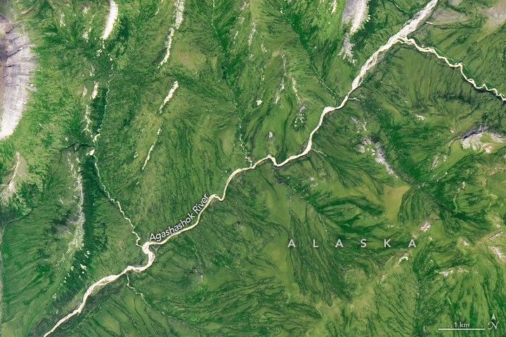 A gently curving river runs from right to left through green tundra vegetation.