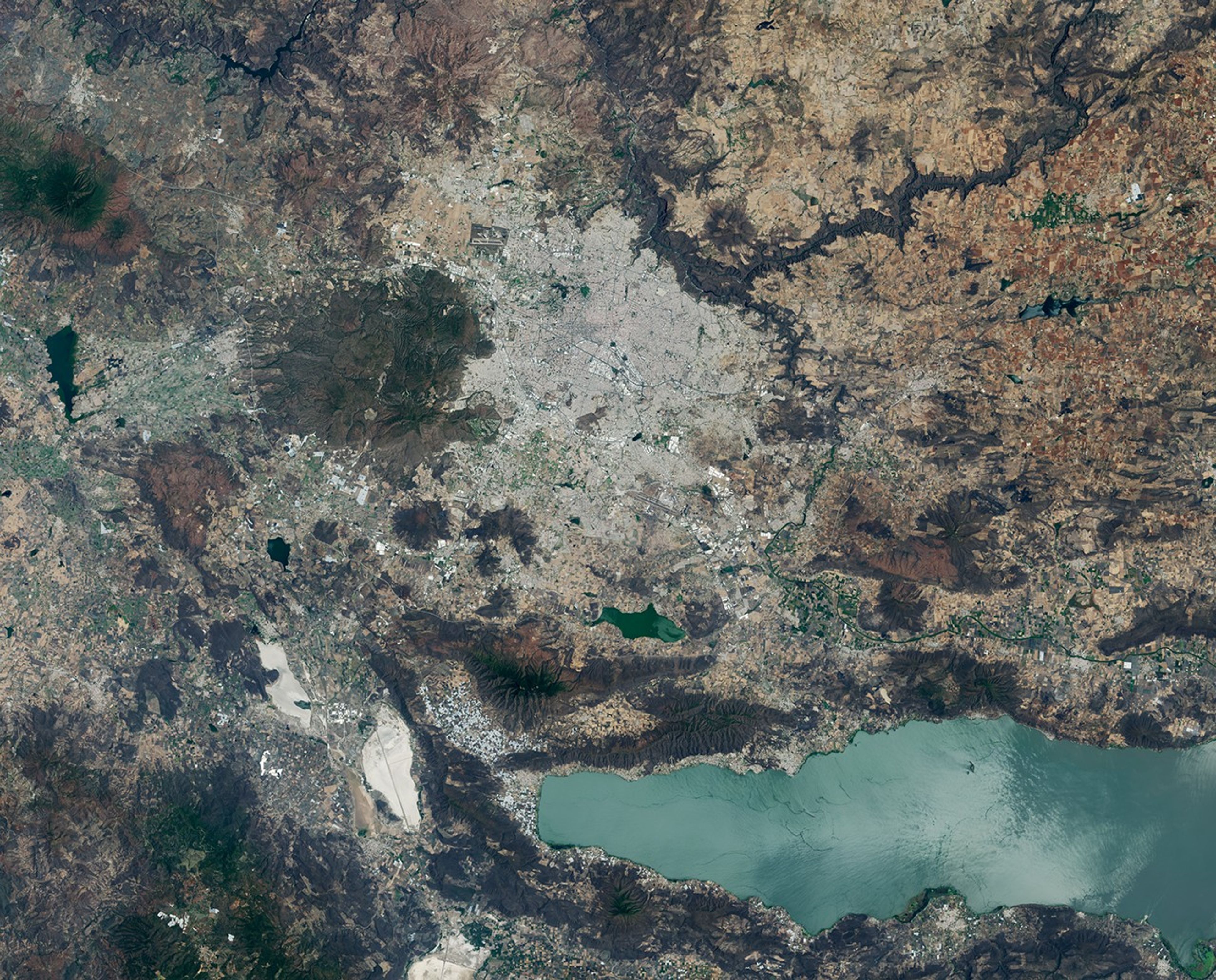 Images of Guadalajara in 1986 (left) and 2026 (right) shows the city expanding westward into an area that had been mostly farmland. Guadalajara Stadium appears as a small circular feature on the left side of the 2026 image.