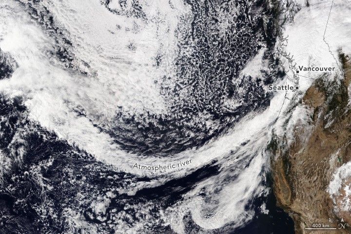 The West Coast of the U.S. and Canada are shown with an arc of dense cloud cover extending from the northern Pacific and obfuscating Seattle and Vancouver