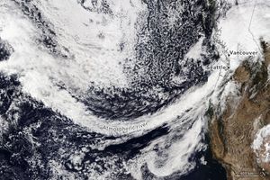 The West Coast of the U.S. and Canada are shown with an arc of dense cloud cover extending from the northern Pacific and obfuscating Seattle and Vancouver