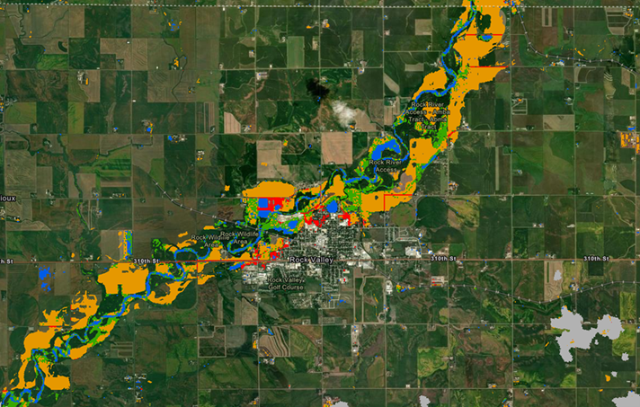 A river path cuts diagonally across the image surrounded by bright color overlays of orange, red, blue and green. The river runs near a human settlement center but the image is primarily comprised of fields.