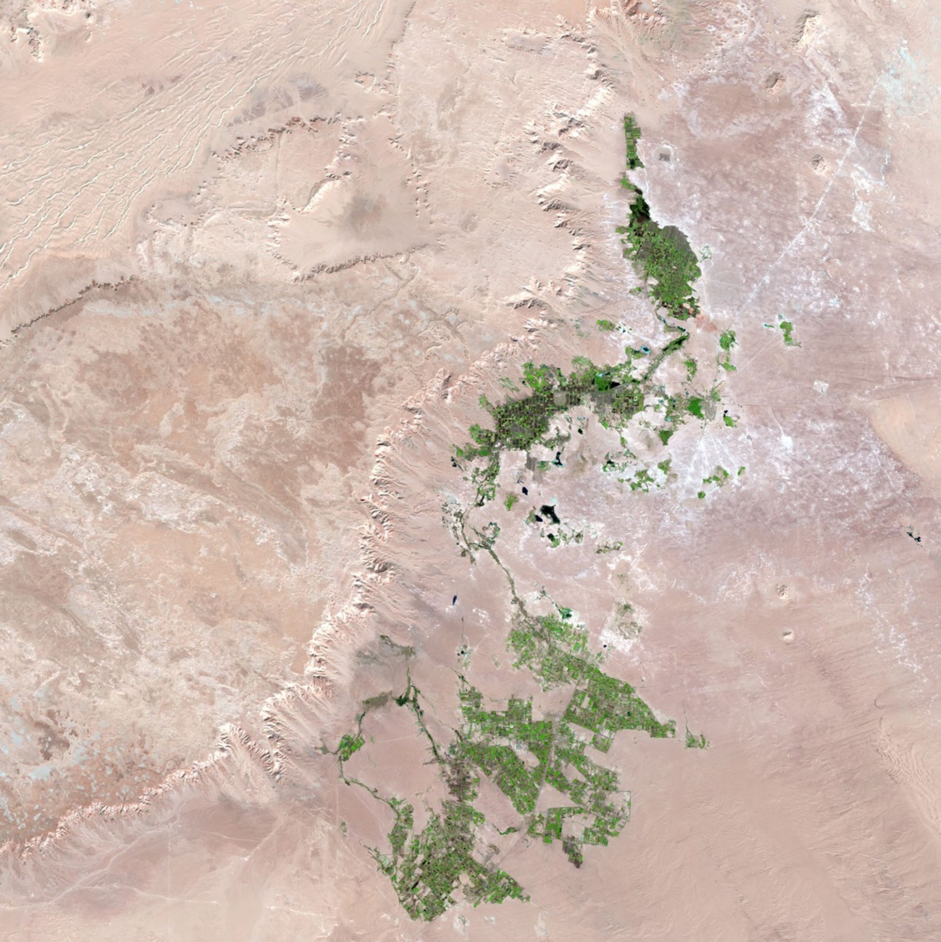 Unlike much newly developed desert agriculture, the western Egyptian fields seen here are watered not by deep-well irrigation, but rather with surface water associated with the Al Farafra Oasis. These images show the increased agricultural activity near the town of Qasr al Farafra. Increased accessibility from improved infrastructure, including paved roads to the town, brings both agricultural laborers and tourists. Images taken by the Thematic Mapper sensor onboard Landsat 5 and the Enhanced Thematic Mapper Plus onboard Landsat 7. Source: U.S. Geological Survey (USGS) Landsat Missions Gallery, "Al Farafra Oasis," U.S. Department of the Interior / USGS and NASA.