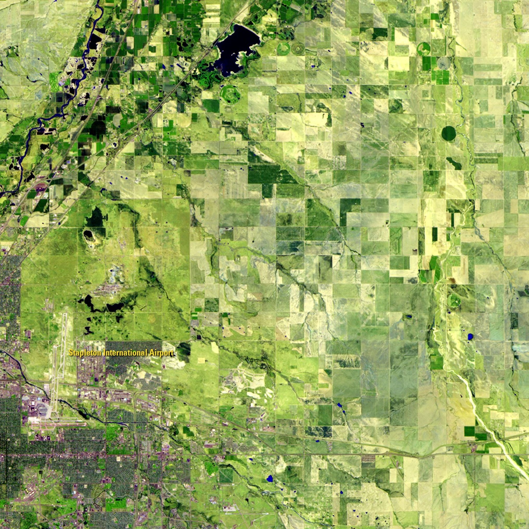 Denver International Airport covers 53 square miles (nearly 140 square kilometers), making it the largest airport in the United States and the third largest in the world. The 1984 image shows the landscape before airport construction began, and the 2011 image shows the same area with the airport in operation. In addition to the aviation hub itself, hotels, manufacturing and residential development have expanded, covering what had previously been farmland. Data from the Landsat satellite are used by regional and local officials to monitor the rate and direction of the expanded development. Images taken by the Thematic Mapper sensor onboard Landsat 5. Source: U.S. Geological Survey (USGS) Landsat Missions Gallery, "Denver International Airport," U.S. Department of the Interior / USGS.