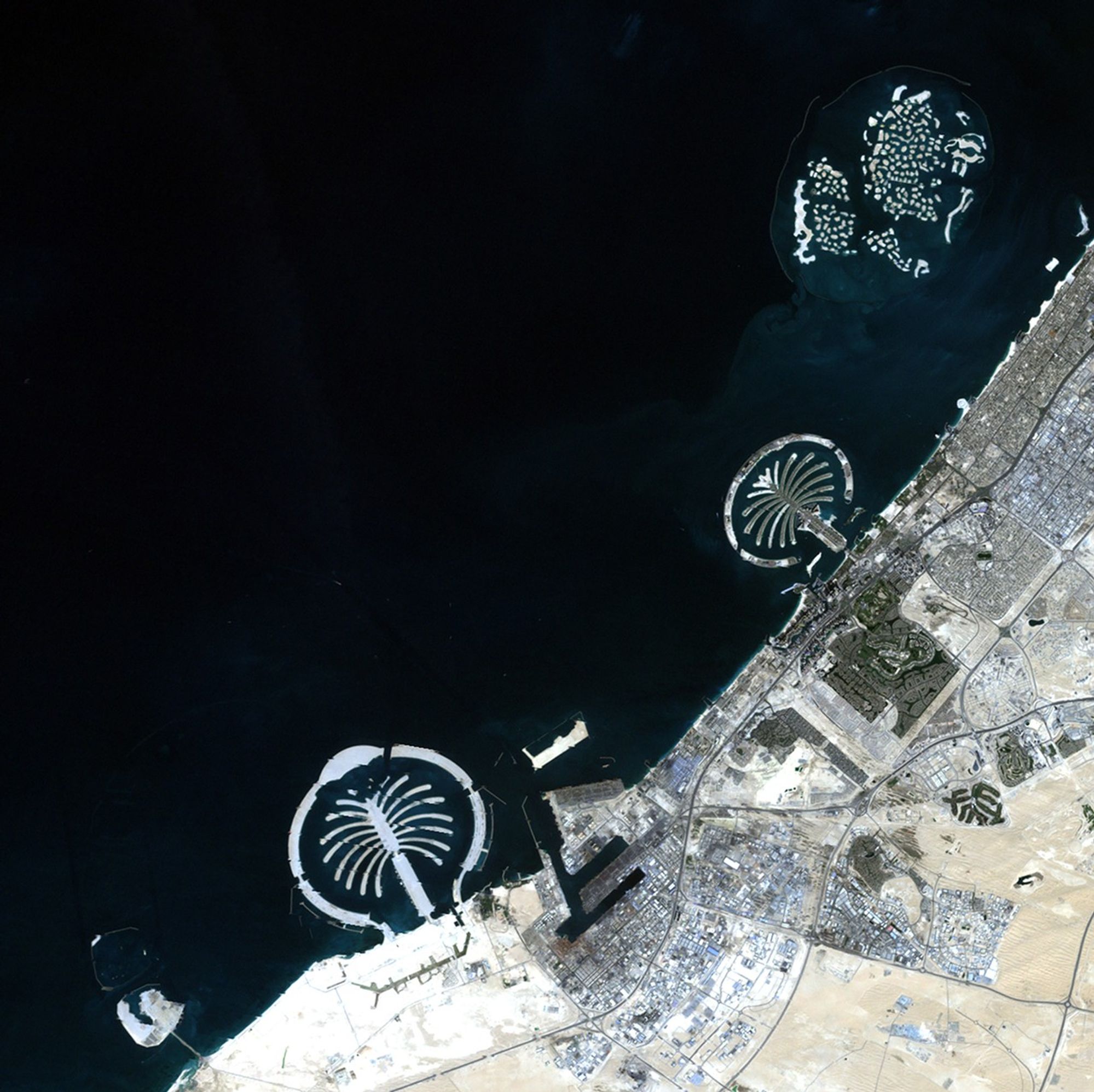 The city of Dubai is situated along the Persian Gulf in the United Arab Emirates. In 2001, work began to create artificial archipelagos along Dubai's shoreline. The results are visible in the 2012 image: Palm Jebel Ali, the smaller Palm Jumeirah and, north of the two "palm islands," a group of smaller islands known as "The World" because they are roughly in the shape of a world map. The World provides an additional 144 miles of shoreline. Images taken by the Enhanced Thematic Mapper Plus sensor onboard Landsat 7. Source: U.S. Geological Survey (USGS) Landsat Missions Gallery “Dubai’s Islands,” U.S. Department of the Interior / USGS and NASA.