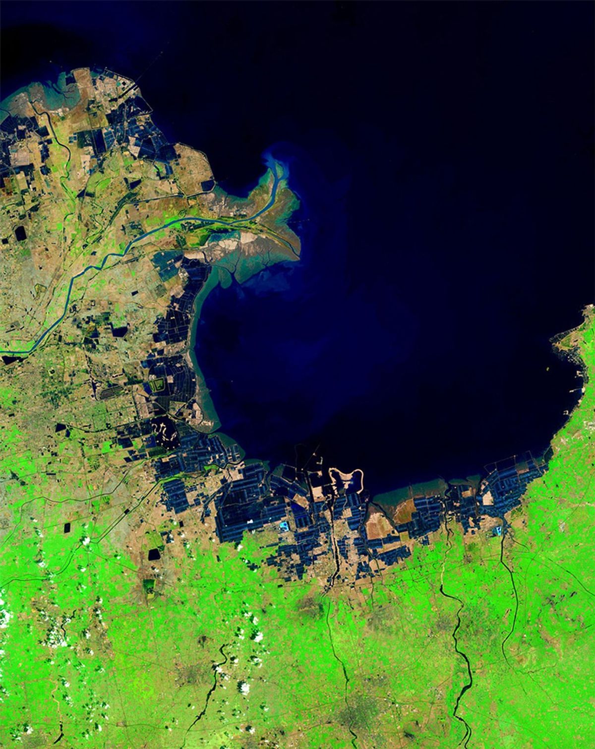 China's Huang He (Yellow) River is the most sediment-filled river on Earth. Each year, it transports millions of tons of soil from a plateau it crosses to a delta it has built in the Bohai Sea. These images show the delta's growth from 1985 to 2014. The latter image also shows another change: ponds that hold shrimp and other seafood (seen here as dark geometric shapes along the coastline) were built on what were once tidal flats.   Images taken by the Thematic Mapper onboard Landsat 5 and the Operational Land Imager onboard Landsat 8. Source: U.S. Geological Survey (USGS) Landsat Missions Gallery "Huang He Delta and Lauzhou Bay," U.S. Department of the Interior / USGS and NASA.