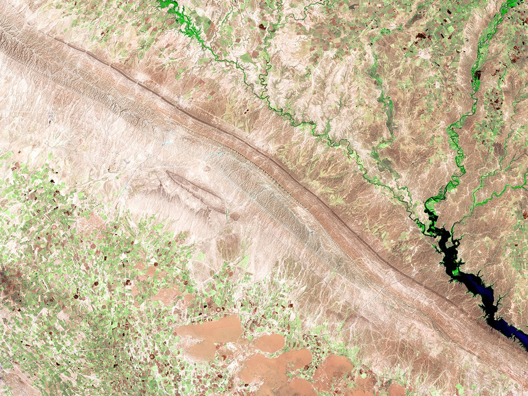 These images show the Hamrin Mountains in northern Iraq before and during an oil well fire. To the left of the thick, dark smoke in the 2017 image, an oil spill is visible flowing over valley agricultural land for about 7 miles (11 kilometers).   2014 image taken by Landsat 8; 2017 image taken by Sentinel-2A. Source: USGS Land Remote Sensing Image Collections.
