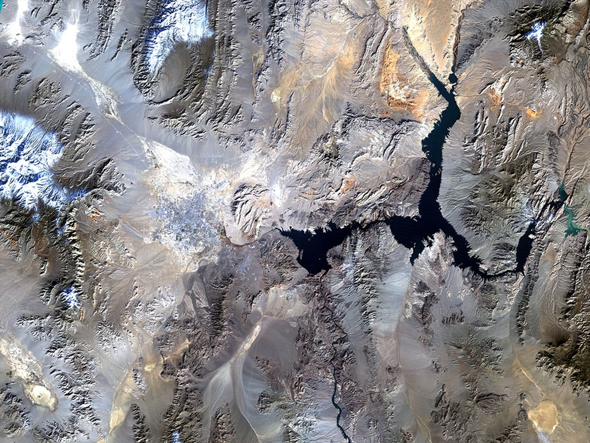 Lake Mead is one of the largest reservoirs in the world, supplying water to California, Arizona, Nevada and Mexico, including the water-guzzling Las Vegas. Through dam turbines, the lake also provides power to Nevada, southern California and northern Mexico. Since 2000, the water level has been dropping at a fairly steady rate due to lower-than-average snowfall and over a decade of drought, and as of July 2010, the lake was at 38 percent of its capacity. Water supply has been further diminished by the drawing off of water from upstream reservoirs in the upper Colorado River Basin which, historically, has been the source for the Lake Mead Reservoir. Also see this image pair of Lake Mead. Images taken by the Thematic Mapper sensor onboard Landsat 5. Source: U.S. Geological Survey (USGS) Landsat Missions Gallery, "Lake Mead, Nevada," U.S. Department of the Interior / USGS.