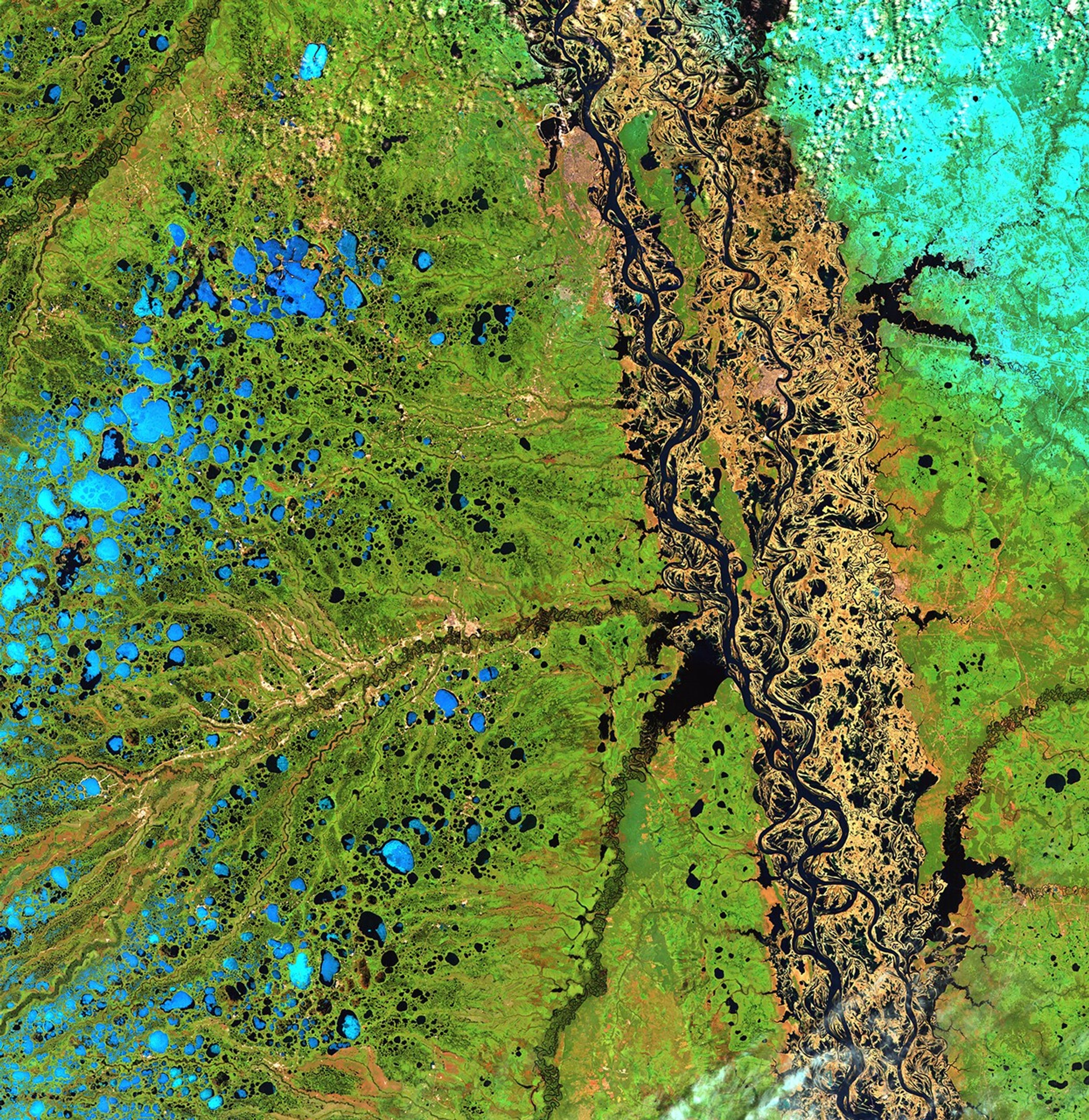 From the time they thaw in early May, the Ob River and its tributary, the Irtysh, flow from the Altay Mountains of northern China to the Arctic Ocean. The northern reaches of the Ob flow over a flat permafrost plain past the cities of Ozernyy and Nefteyvgansk in northern Russia. Because the river cannot cut deep channels into the frozen land, it spreads out over the surrounding plain during the spring melt, as shown in the image on the right. Images taken by the Thematic Mapper sensor onboard Landsat 5. Source: U.S. Geological Survey (USGS) Landsat Missions Gallery, "Ob River Flooding in Northern Russia," U.S. Department of the Interior / USGS and NASA.