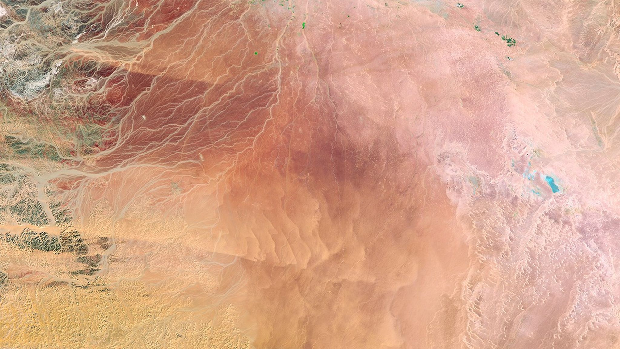 Water lying deep beneath the sand for thousands of years has enabled Saudi Arabia to transform desert in the Wadi As-Sirhan basin into productive farms. Some of the green fields seen here—circular because each is irrigated with a sprinkler system that rotates around the field like the hands of a clock sweep around the clock’s face—are as large as 1 kilometer (about two-thirds of a mile) across. But the region’s rainfall is too little to recharge the aquifer and hydrologists estimate that pumping will be feasible for only another 50 years. Farmers are encouraged to switch to more sustainable methods, such as greenhouse farming with drip irrigation. 1986 image: Landsat 5. 2016 image: The Operational Land Imager onboard Landsat 8. Source: U.S. Geological Survey (USGS) Landsat Missions Gallery; U.S. Department of the Interior / USGS and NASA.