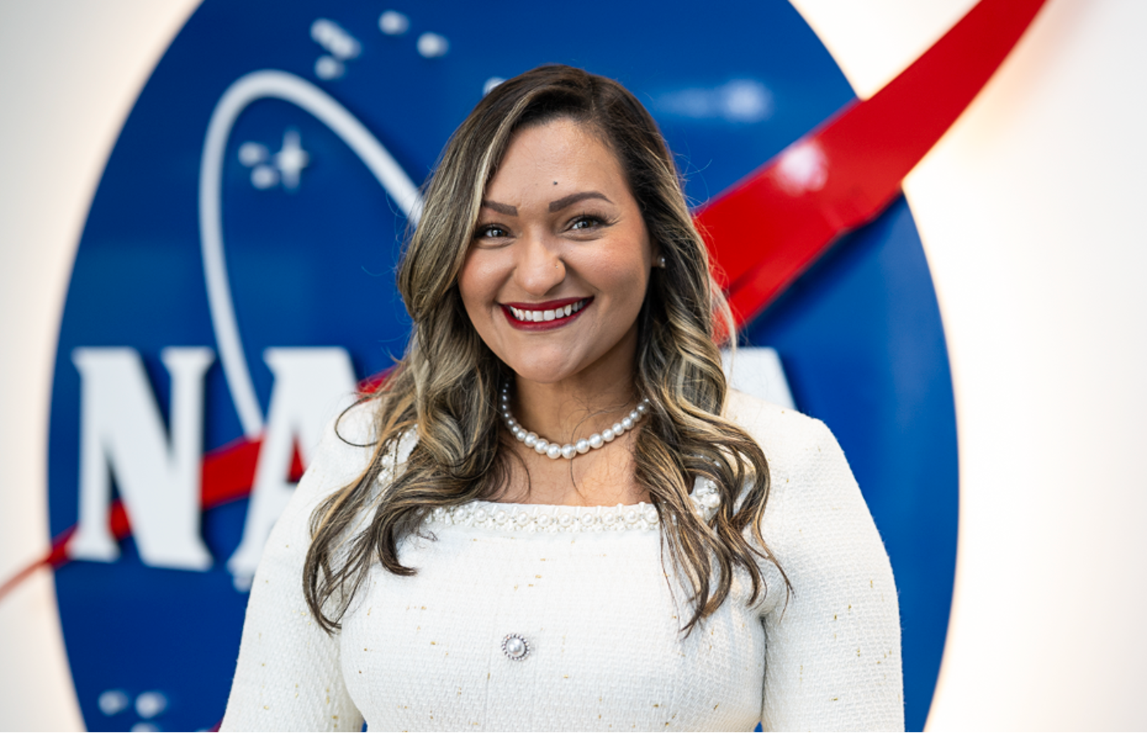 Dr. Yaitza Luna-Cruz photo in front of the NASA logo