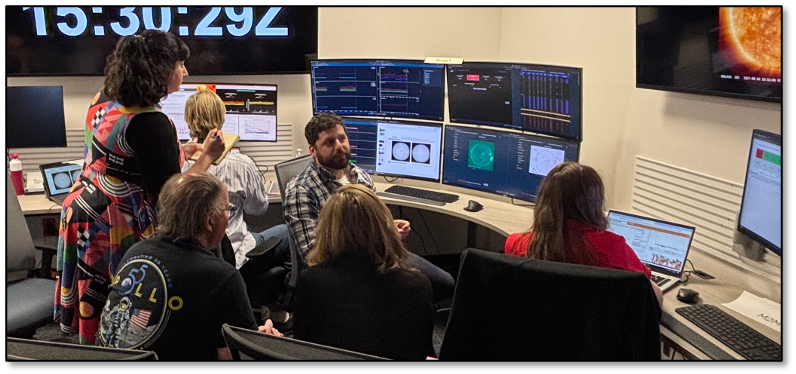 A group of people focus on computer monitors as part of the Artemis II Space Weather Testbed Exercise