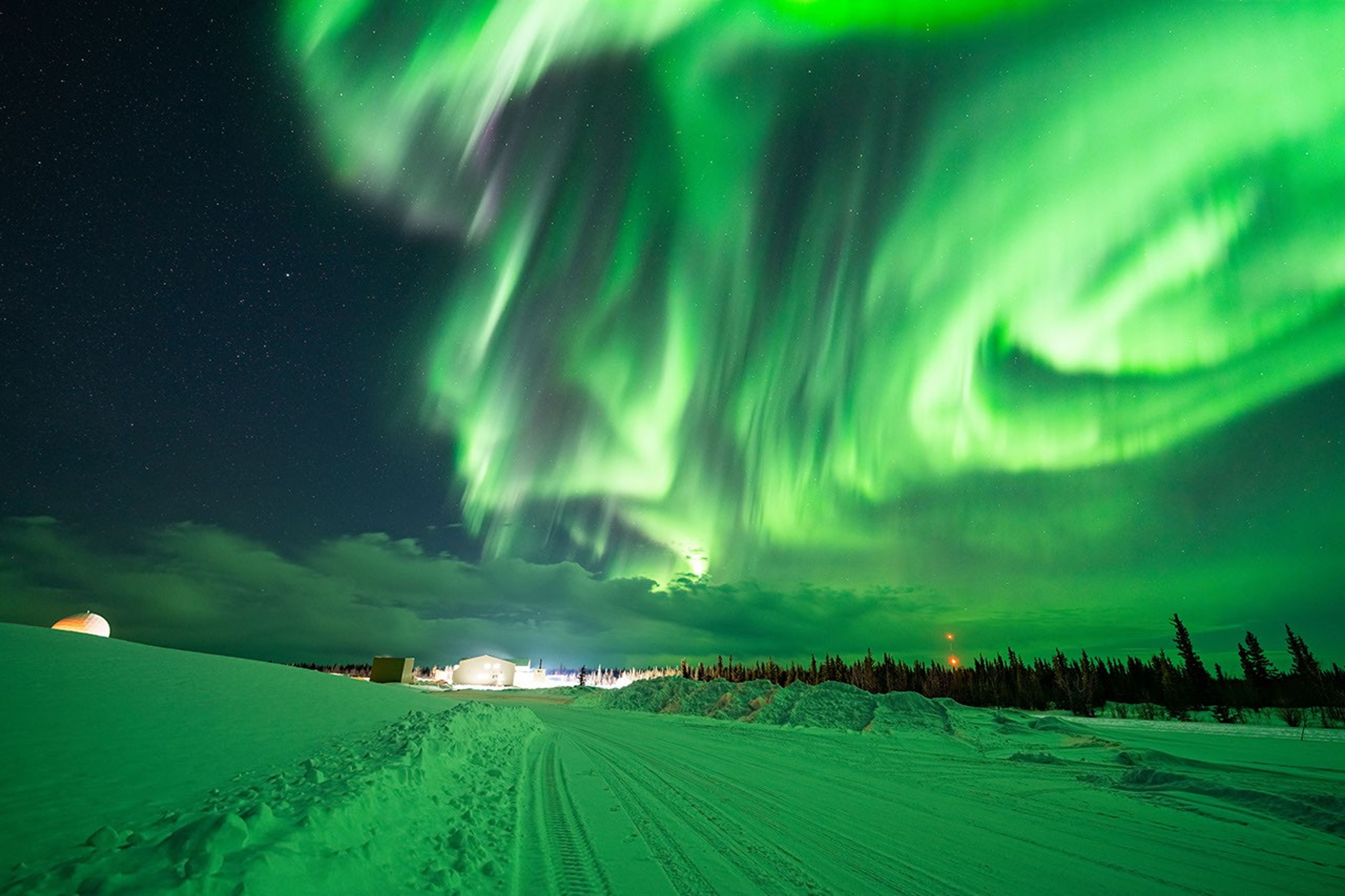 Bright green auroral swirls appear in the sky over Fort Yukon, Alaska
