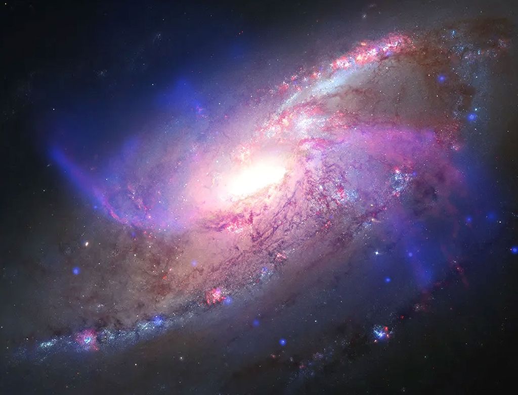 A spiral galaxy famous for having two extra, "anomalous" spiral arms composed of hot gas. Chandra's X-rays (royal blue) show superheated shockwaves created by central black hole jets, combined with optical light from Hubble (red, yellow and pale blue) and infrared dust filaments from Webb (bright orange). M106 helps show how supermassive black holes can create structural features that mimic star-bearing spiral arms, influencing a galaxy's evolution.