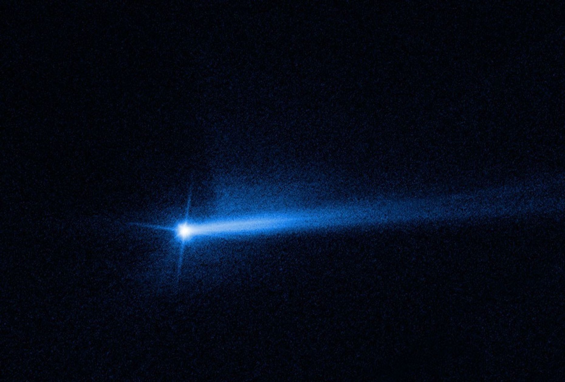 Bright blueish white dot with a glowing blue line extending to the right against a black background.