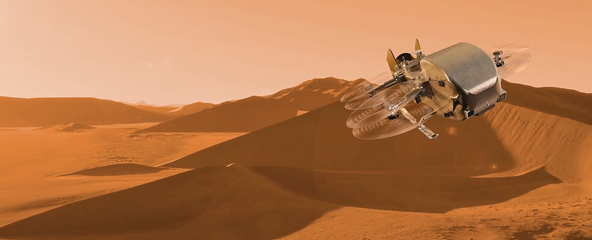 La aeronave de ala giratoria Dragonfly de la NASA vuela sobre la superficie de tono anaranjado y cubierta de dunas de la luna de Saturno, Titán, en esta representación digital.