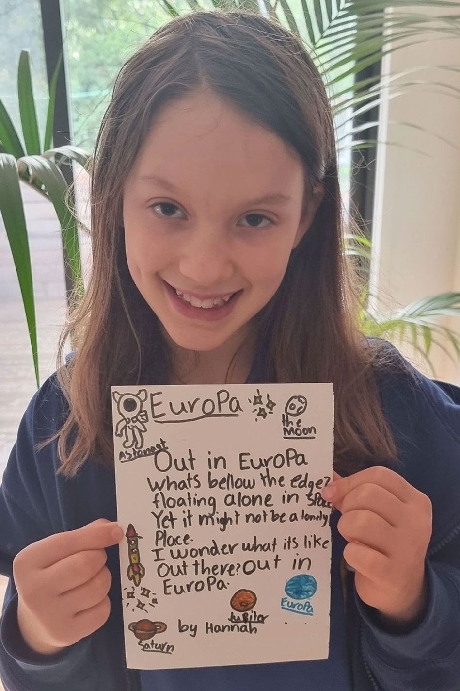 A young girl holding up a handwritten message to Europa.