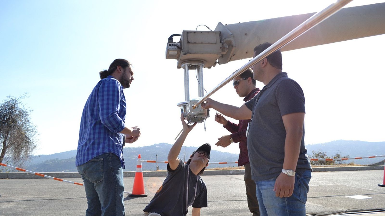 four engineers examining a Europa Clipper instrument