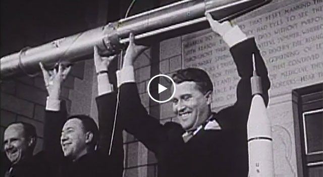 This iconic black-and-white historic photograph captures William Pickering, James Van Allen, and Wernher von Braun triumphantly holding a full-scale model of the Explorer 1 satellite above their heads during a press conference at the National Academy of Sciences. The three men are smiling broadly as they celebrate the successful launch of America's first satellite on January 31, 1958. In the background, an inscription on the stone wall is partially visible, while a smaller rocket model stands on a table in the lower right corner, symbolizing the beginning of the U.S. space age.