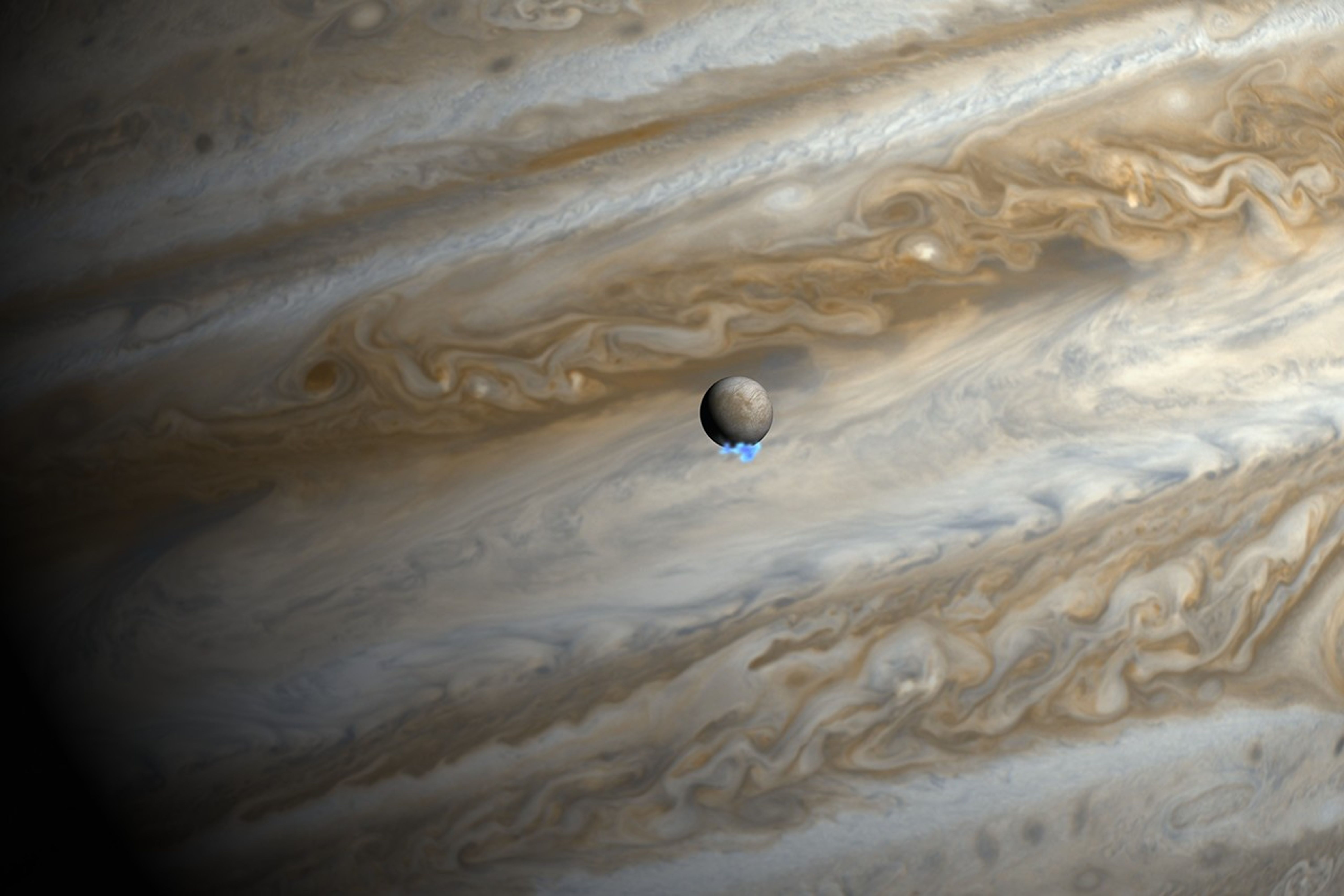 The orange, white, gray, and brown bands of Jupiter's clouds make up the backdrop of this image. Near the center is a small gray sphere with brown patches, and a small, bright-blue plume at the bottom.
