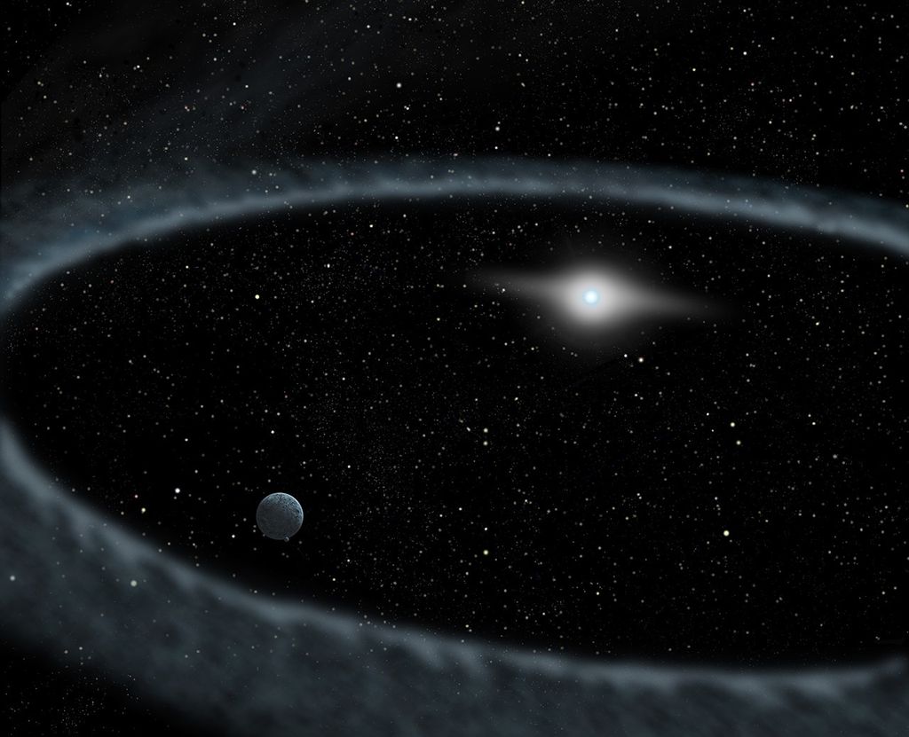 Against the black background of space with many multicolored stars scattered throughout, near the center, a bluish-white star appears a bit larger and shines brighter, with a white glow around it shaped like the iris of an eye. At a distance, a gray ring of dust circles the star. Inside the ring, in the lower-left quadrant, is the gray sphere of a planet.