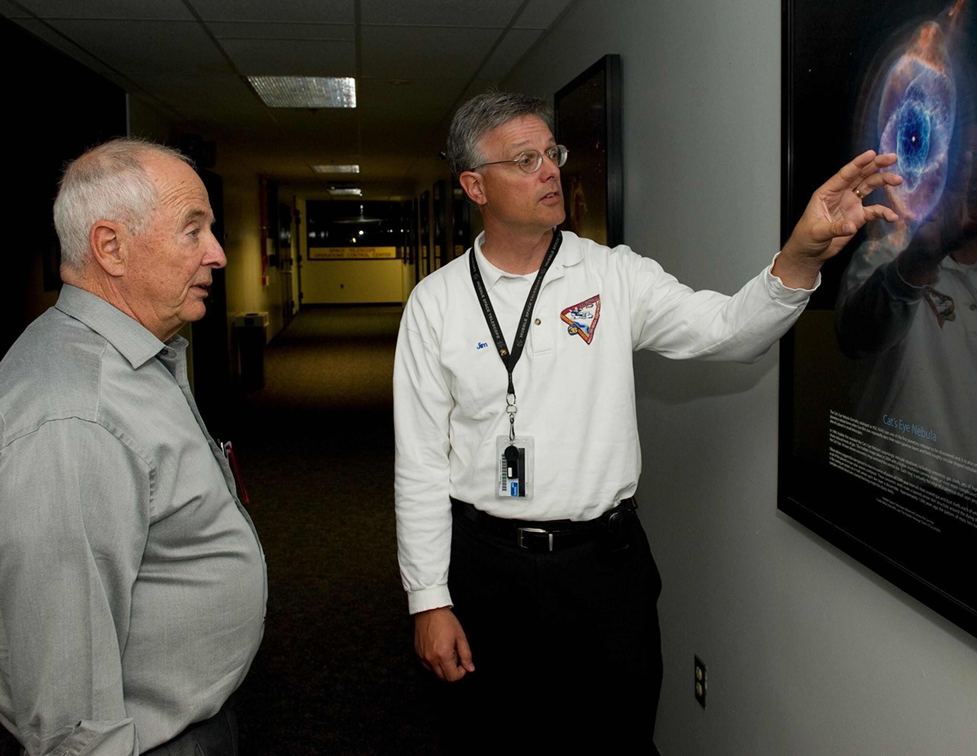 Jim Jeletic, right, explains an image of the Cat's Eye Nebula (while gesturing to it with one hand) to Bill Anders, left.