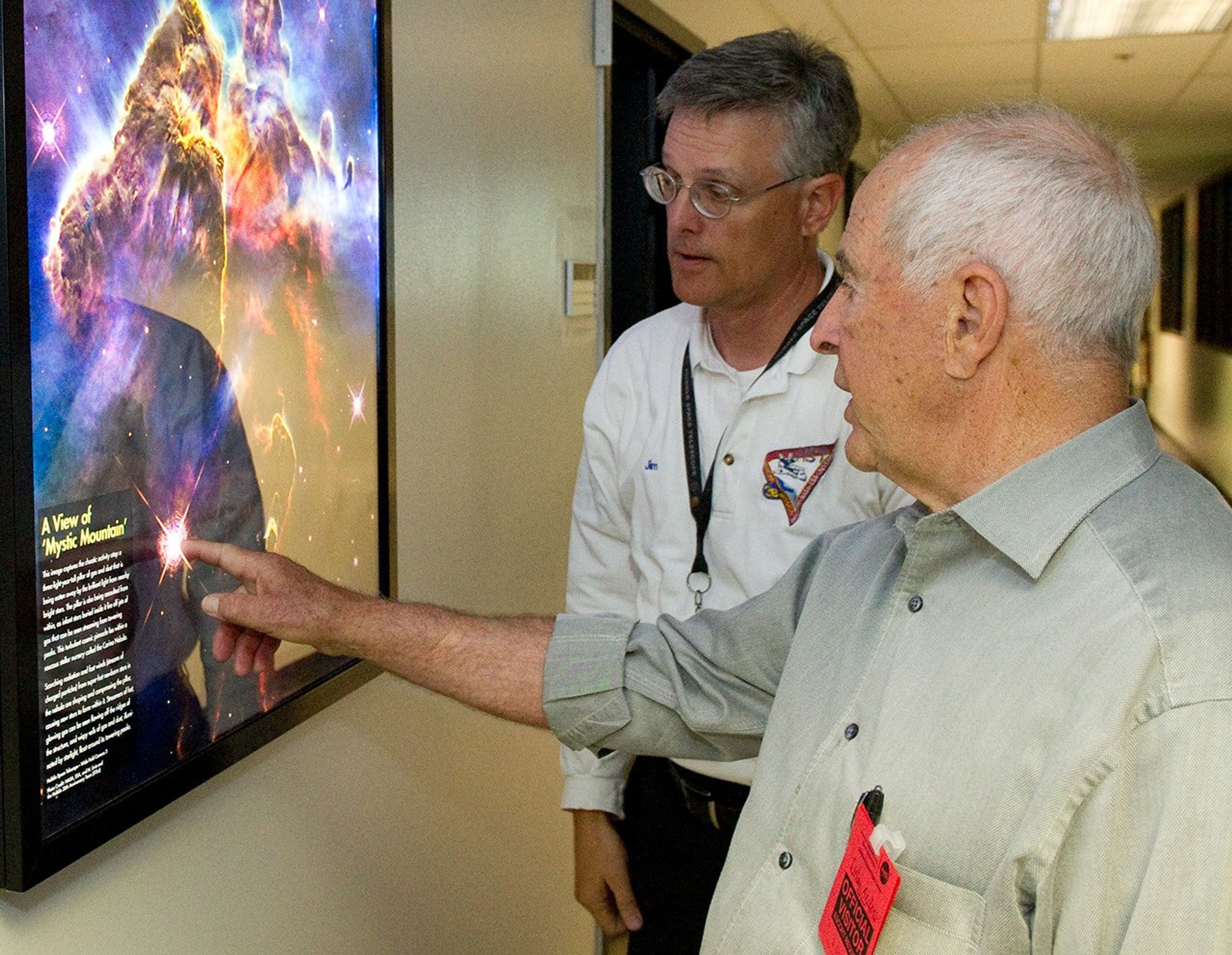 Bill Anders, right, points to a framed picture of Mystic Mountain while asking Jim Jeletic, left, a question.