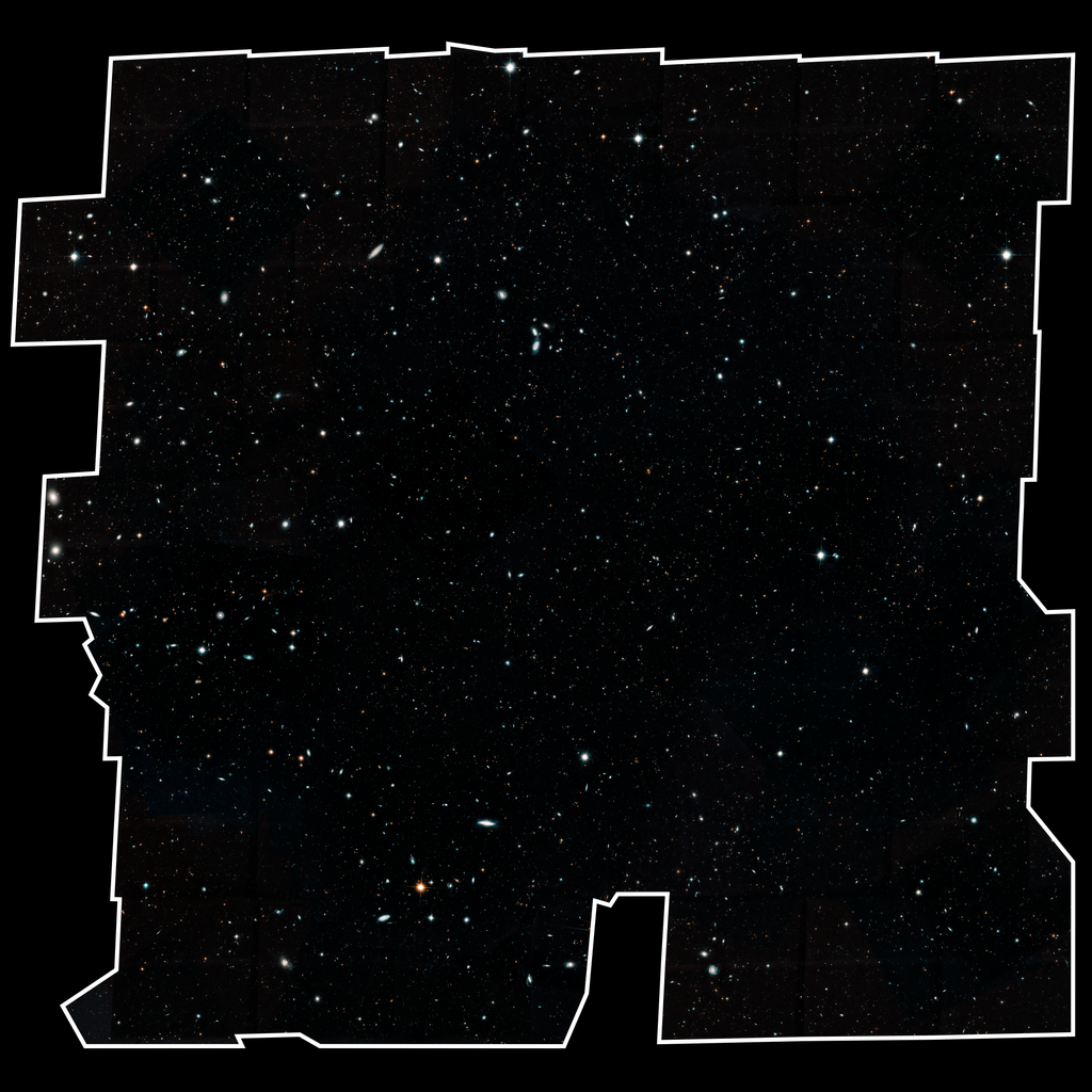 Image is filled with distant galaxies in colors of yellow-gold, red, blue, white. Many of the stars and galaxies have a bluish tint. The field is outlined in white, on a plain black background.