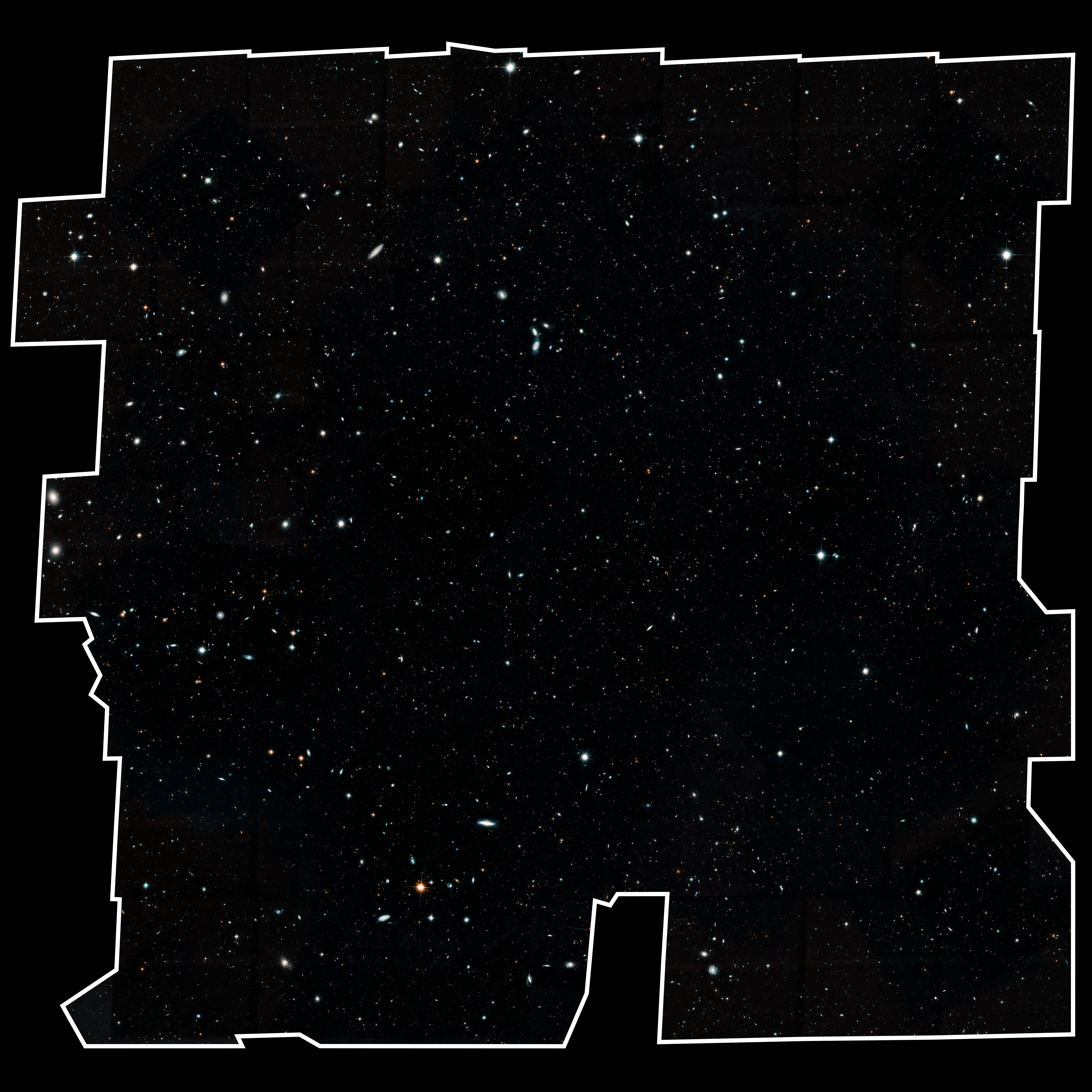 Image is filled with distant galaxies in colors of yellow-gold, red, blue, white. Many of the stars and galaxies have a bluish tint. The field is outlined in white, on a plain black background.