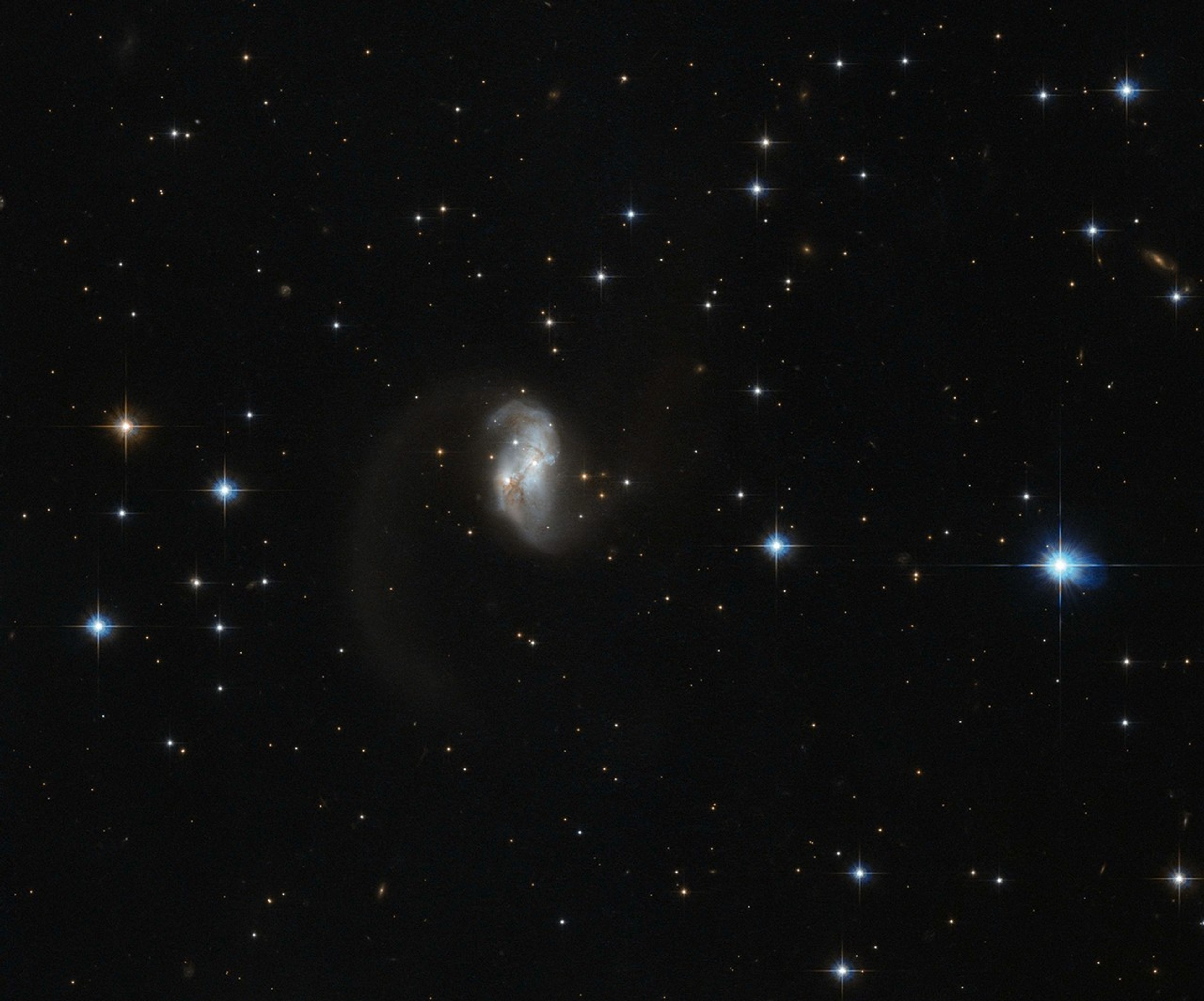 The central portion of this spiral galaxy is the only part visible, giving it an asymmetric form with a tail.