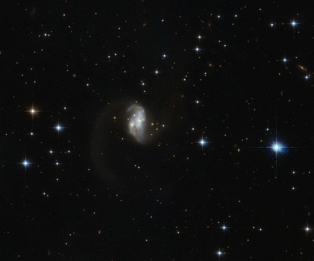 The central portion of this spiral galaxy is the only part visible, giving it an asymmetric form with a tail.