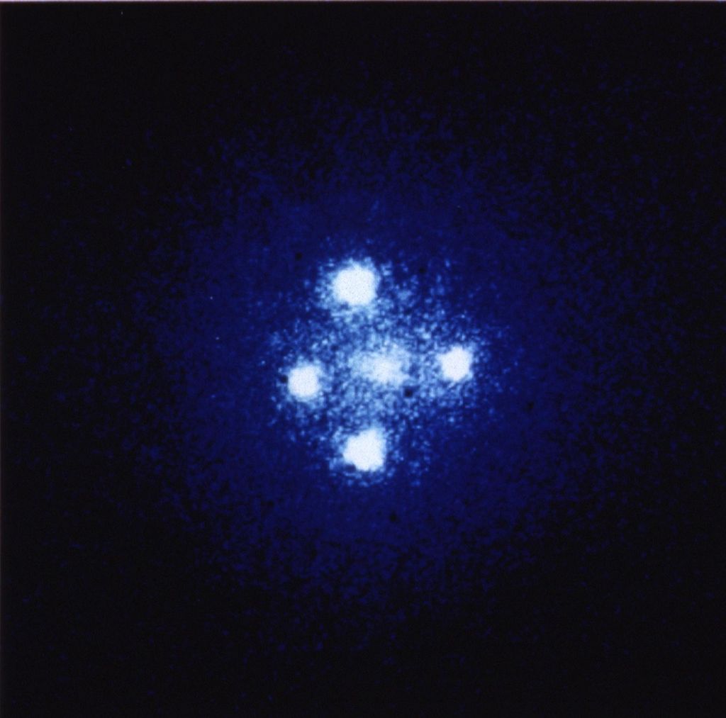 Four bright-white circles, positioned in the shape of a cross around a fifth more muted white spot in the center.