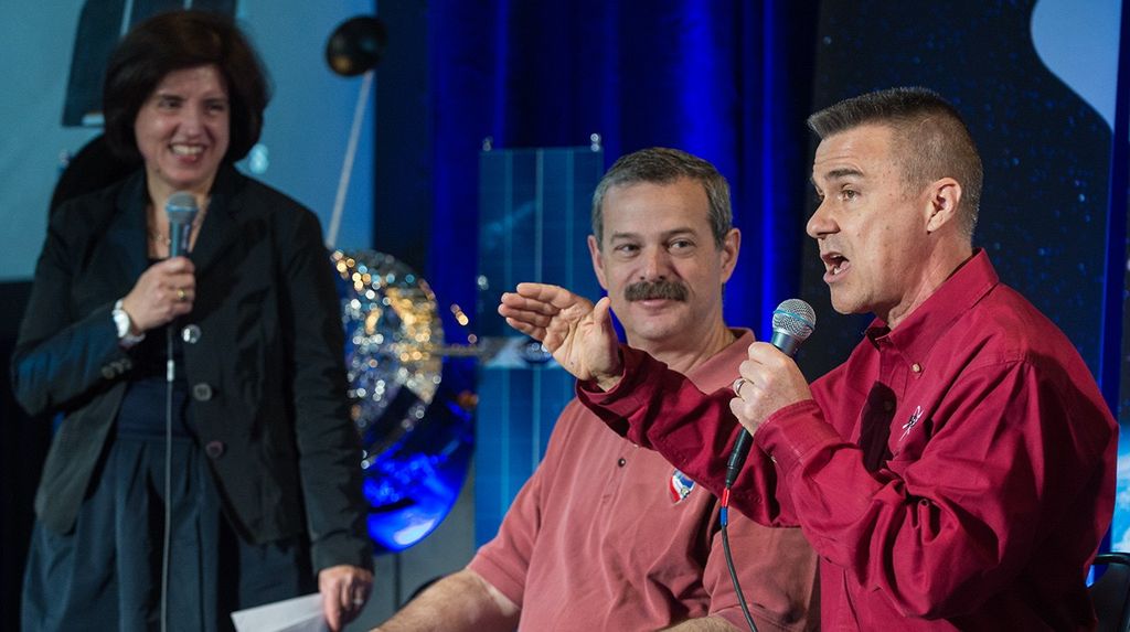 Dane Carey (right) addresses the audience, while fellow astronaut Scott Altman (center) and moderator Antonella Nova (left) smile at his words.