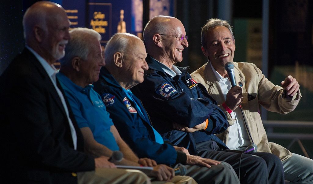 Jean-Francois Clervoy, far-right and farthest from the camera, addresses the audience while sitting on the panel with four fellow astronauts.