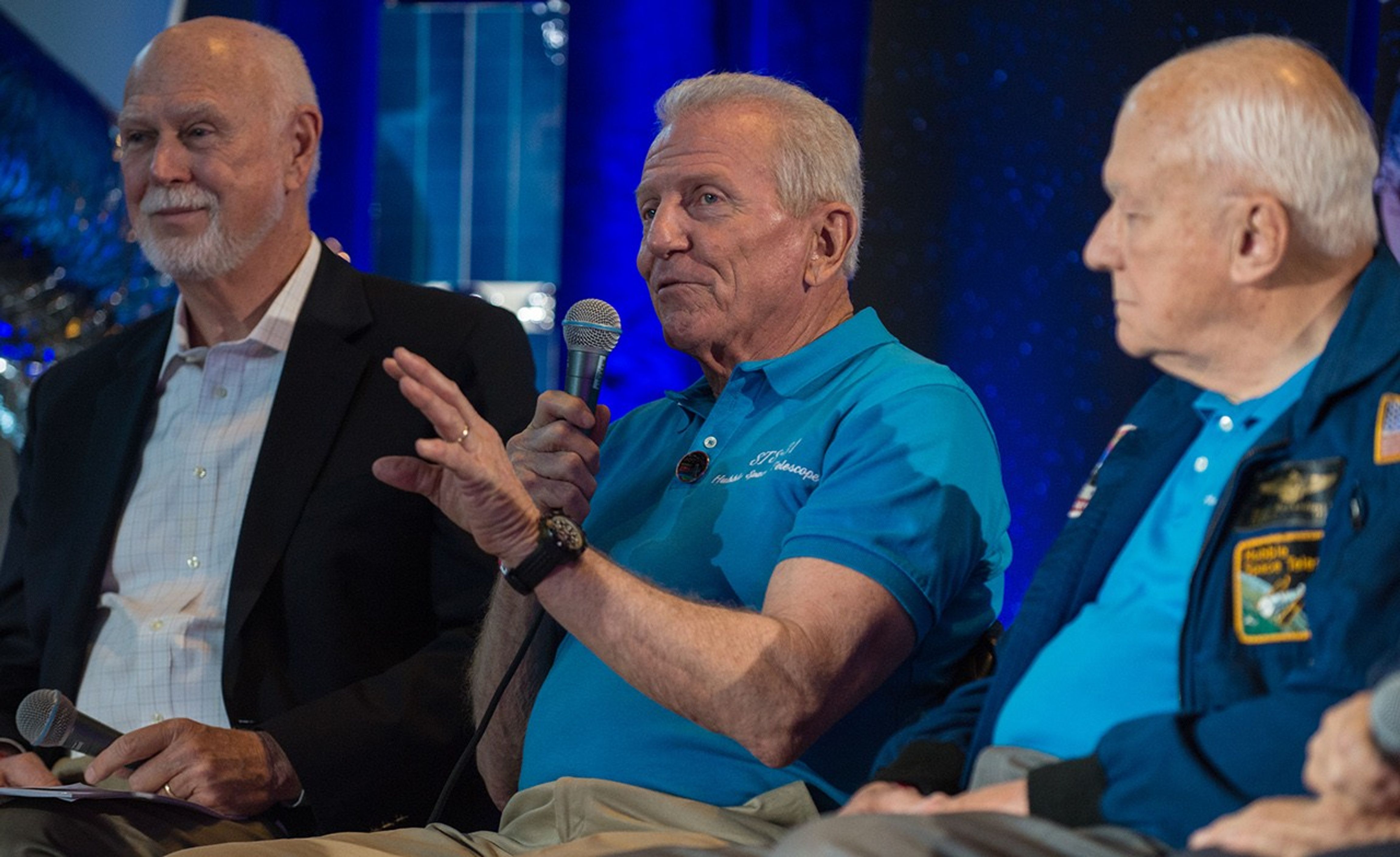 Loren Shriver (center) addresses the audience, while Jim Crocker (left) and Bruce McCandless (right) listen.