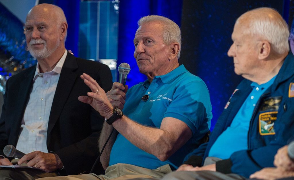 Loren Shriver (center) addresses the audience, while Jim Crocker (left) and Bruce McCandless (right) listen.