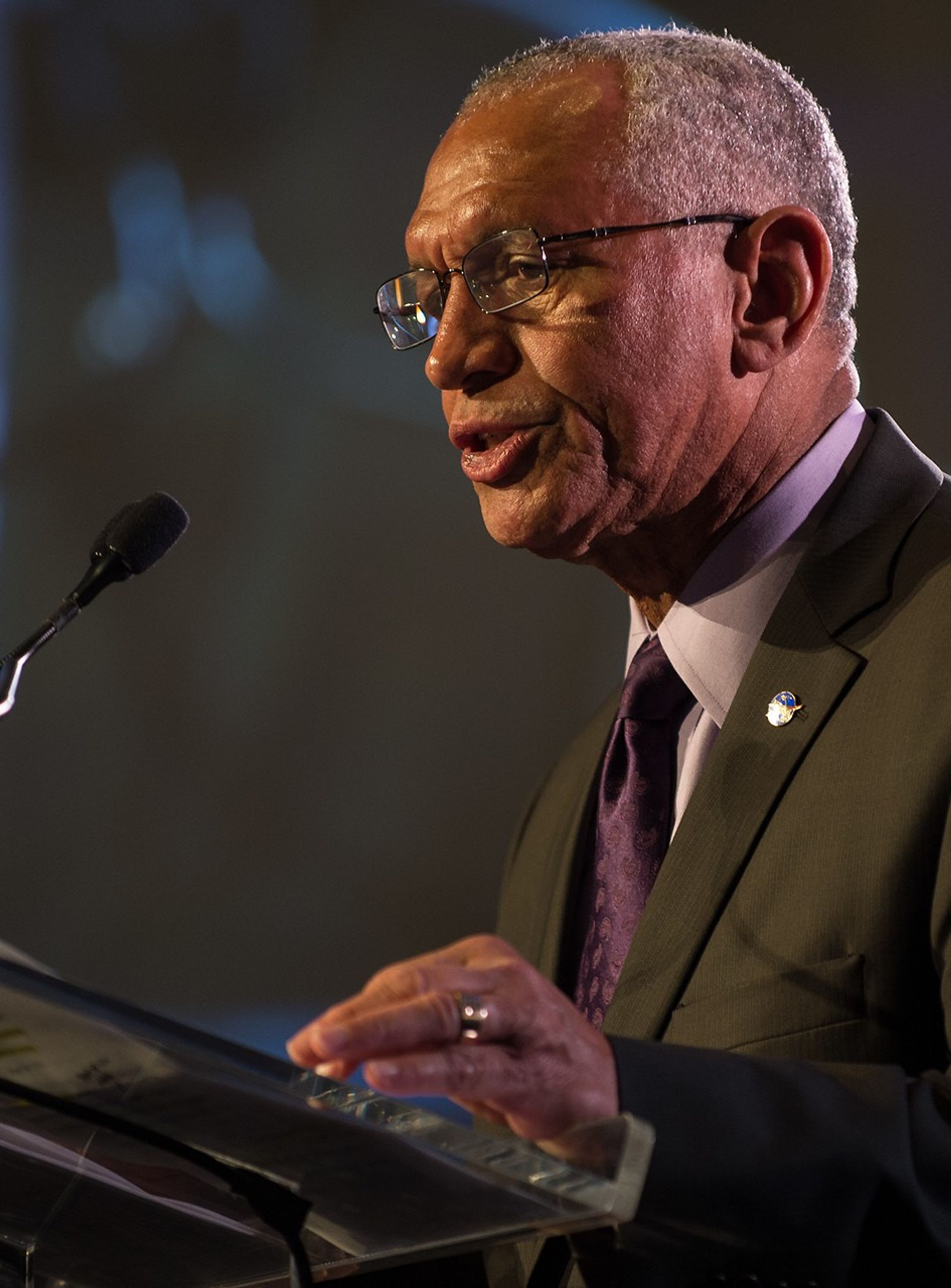 Charlie Bolden stands at the podium, addressing the audience.
