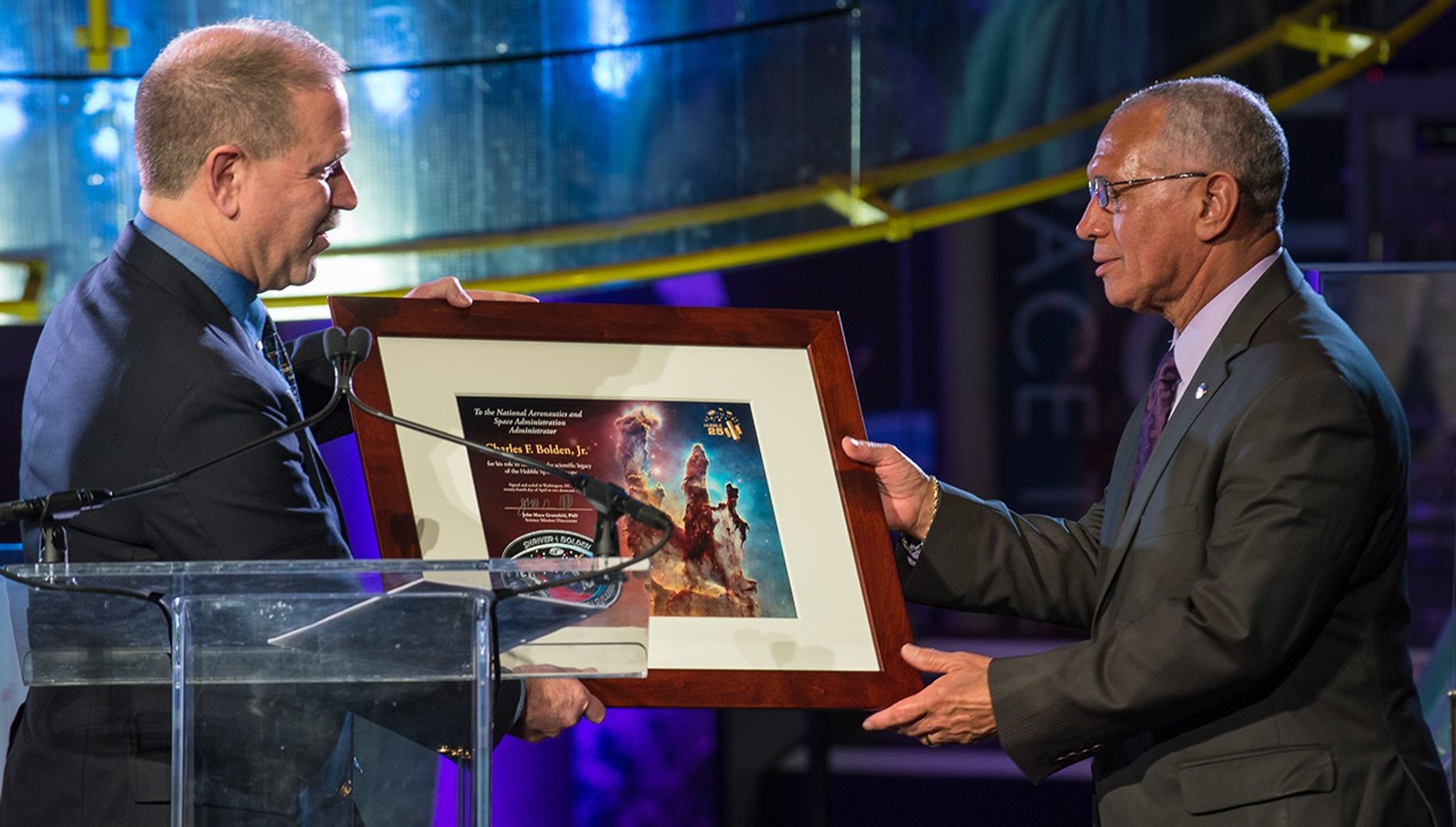 John Grunsfeld presents Charlie Bolden with a framed Hubble plaque.