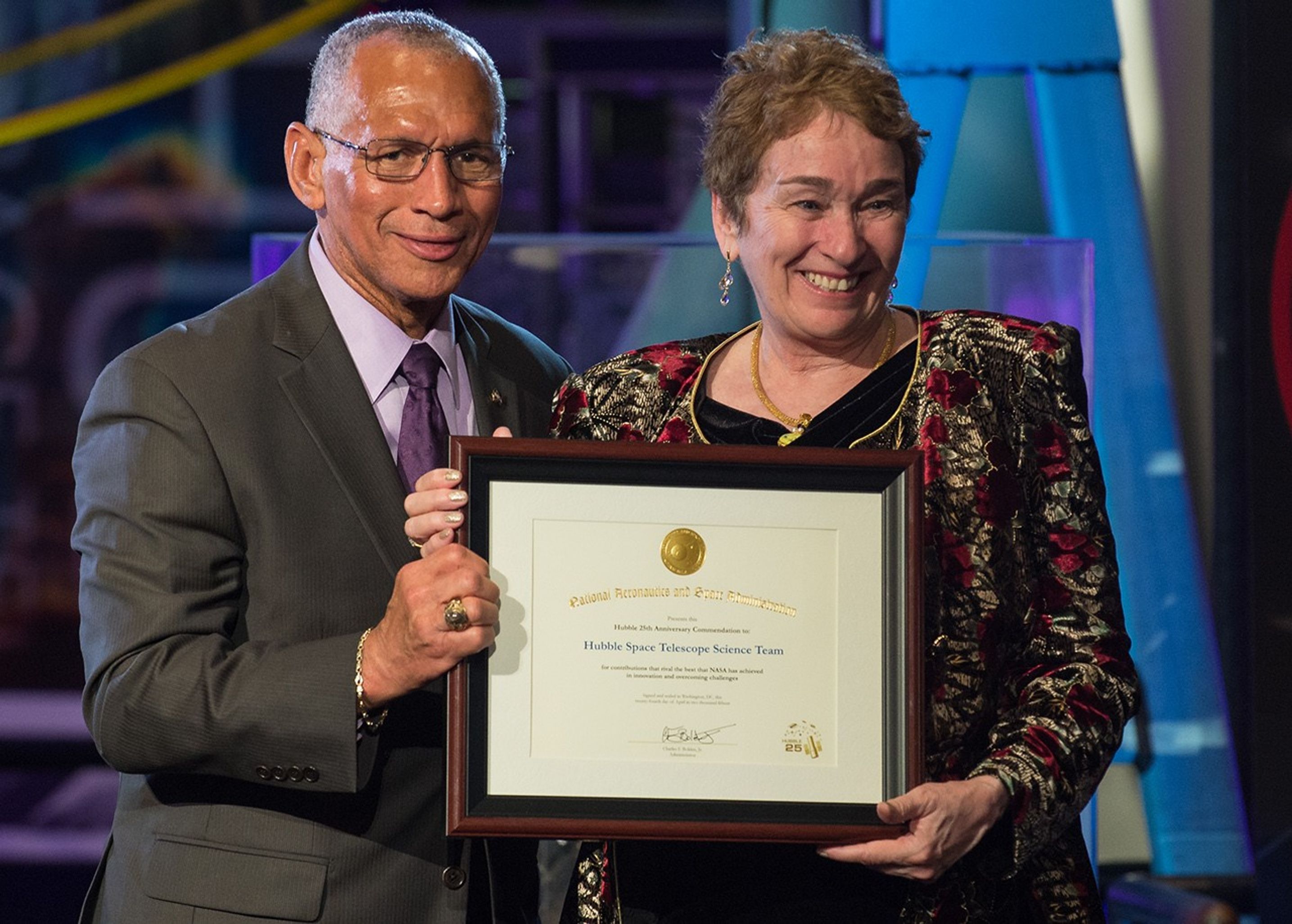Flanagan, standing on the right, accepts an award from Bolden, on the left.
