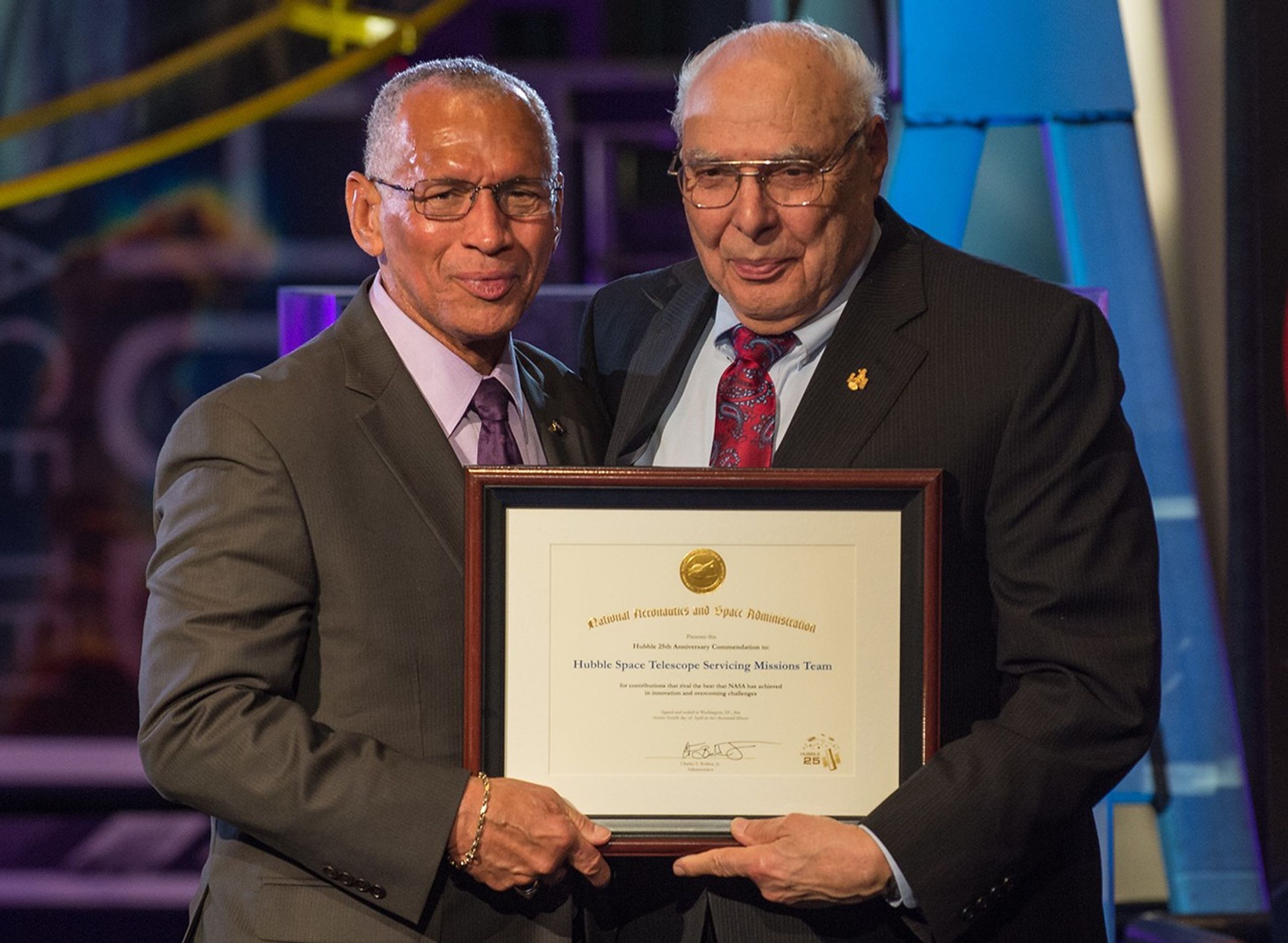 Charlie Bolden and Frank Cepolina stand side-by-side, both holding Cepolina's award with one hand each.