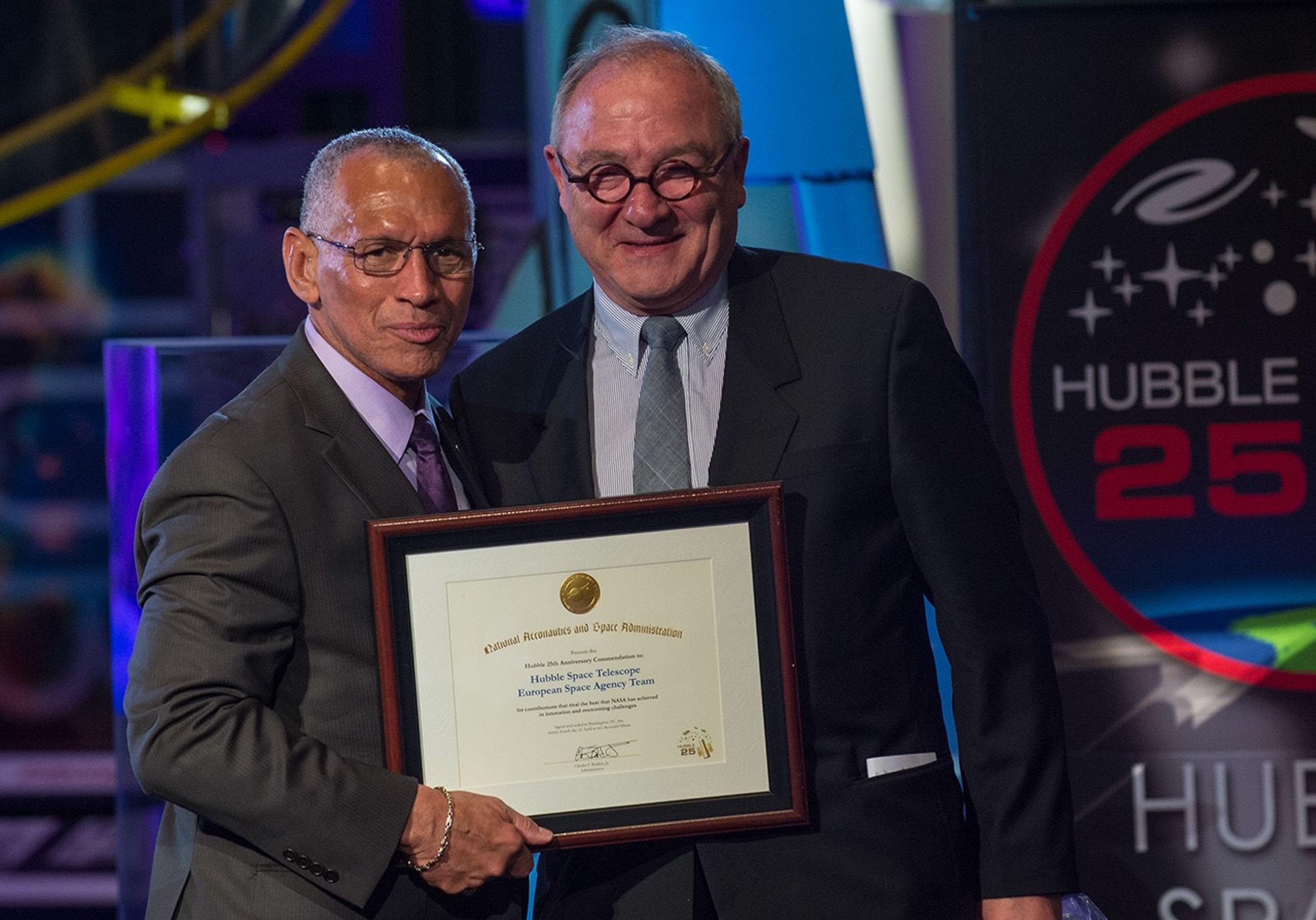 Charlie Bolden and Jean-Jacques Dordain stand side-by-side, with Bolden holding Dordain's award.