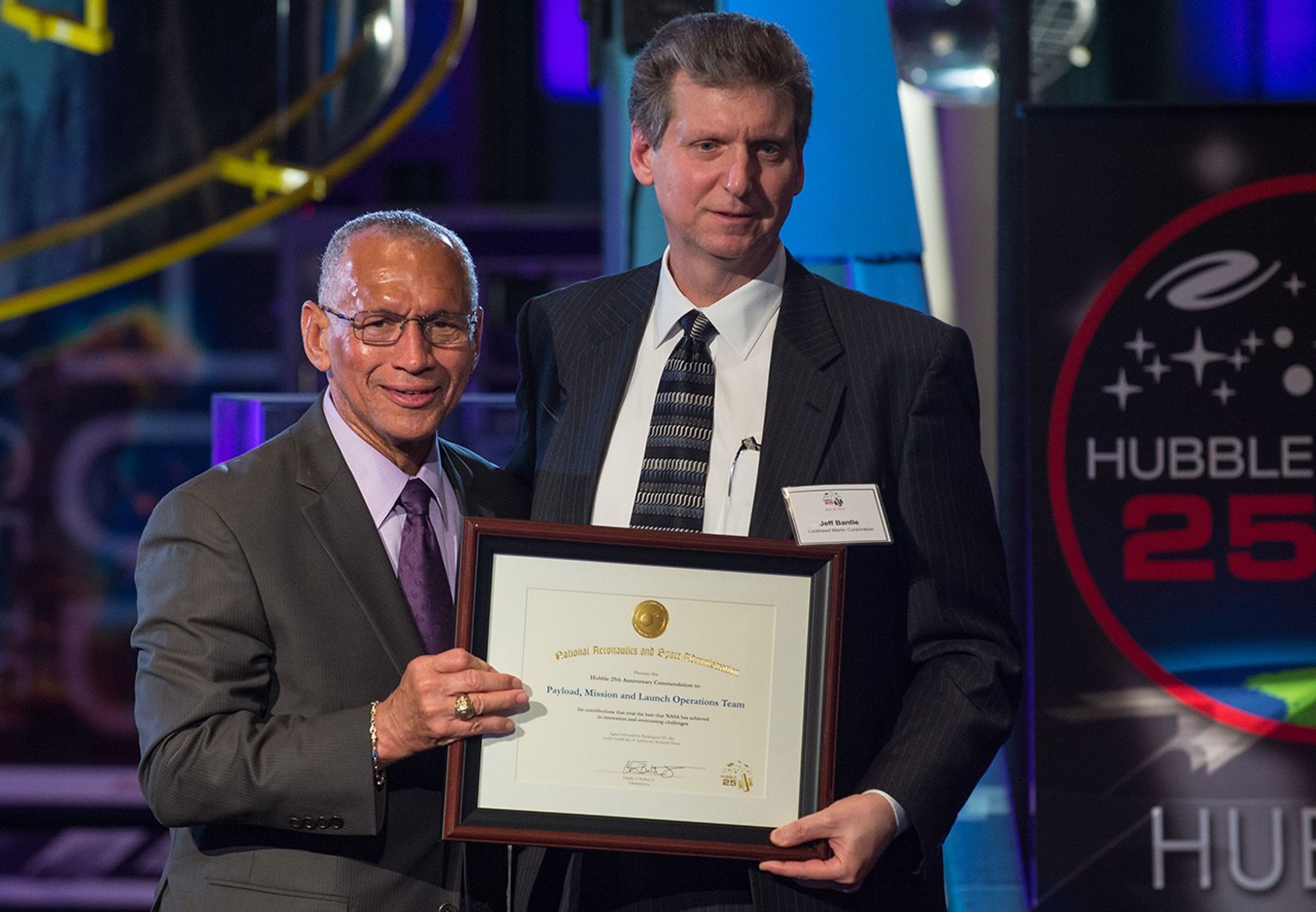 Charlie Bolden and Jeffery Bantle stand side-by-side, both holding Bantle's award with one hand each.
