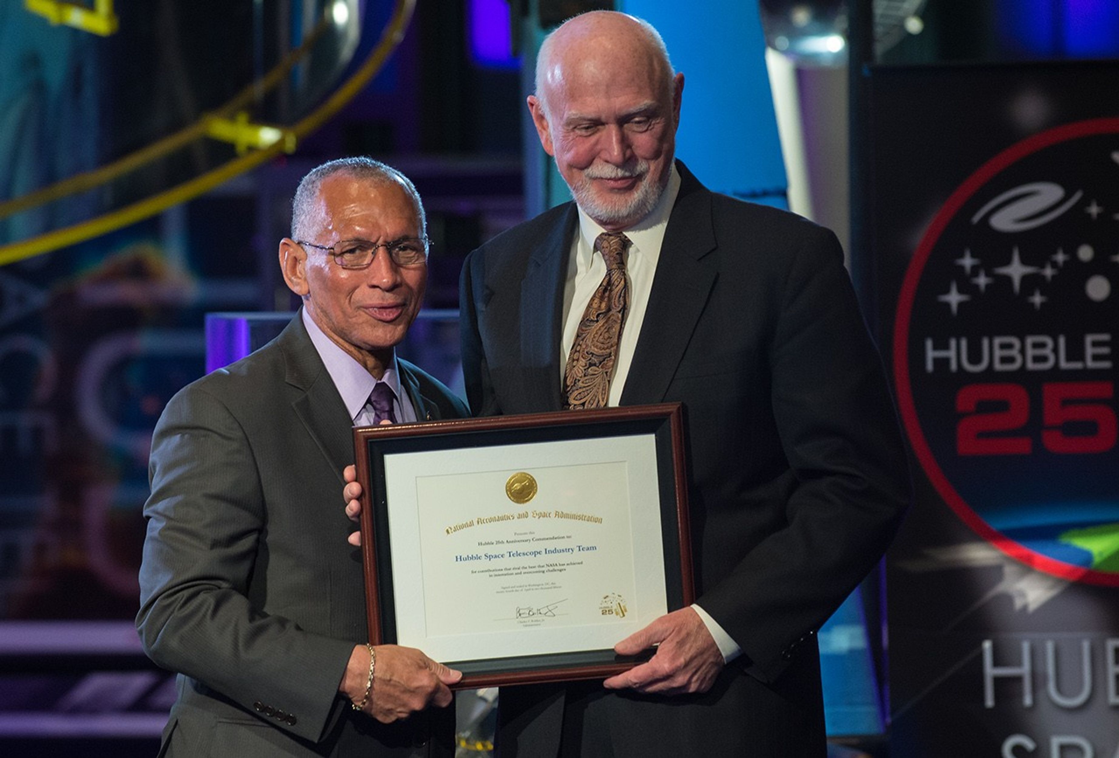 Charlie Bolden and Jim Crocker stand side-by-side, both holding Crocker's award.