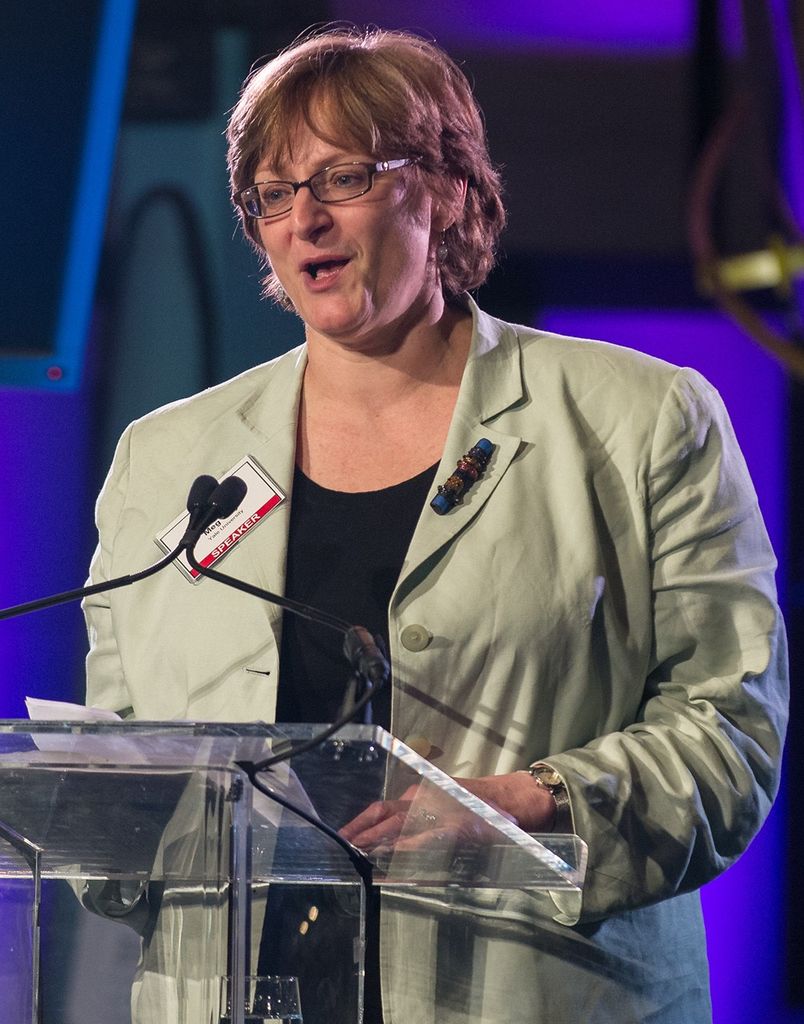 Meg Urry stands at the podium, addressing the audience.