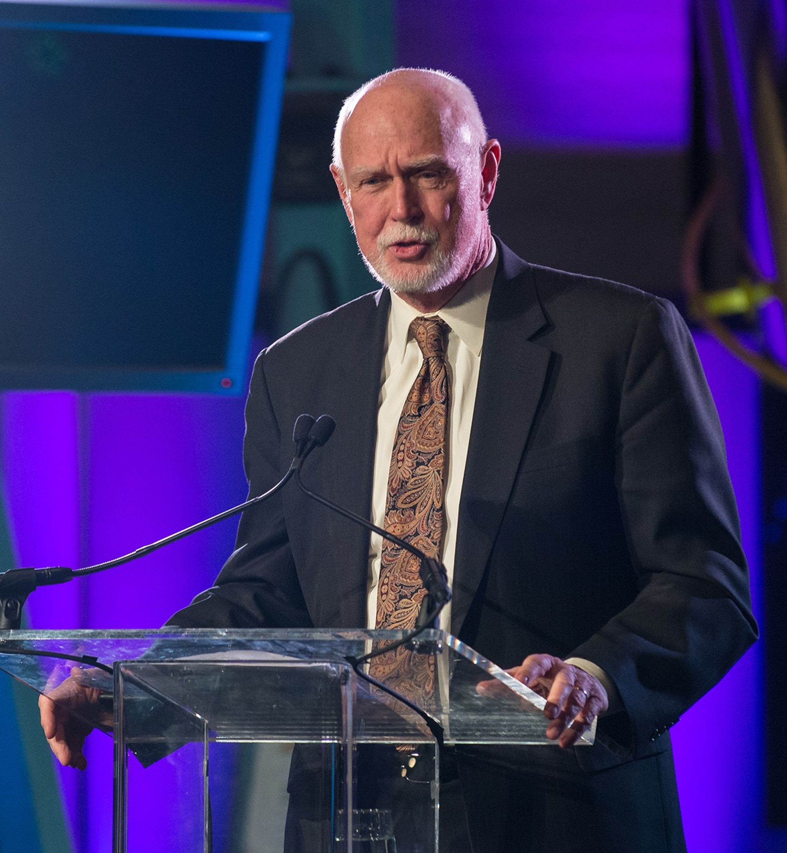 Jim Crocker stands at the podium, addressing the audience.
