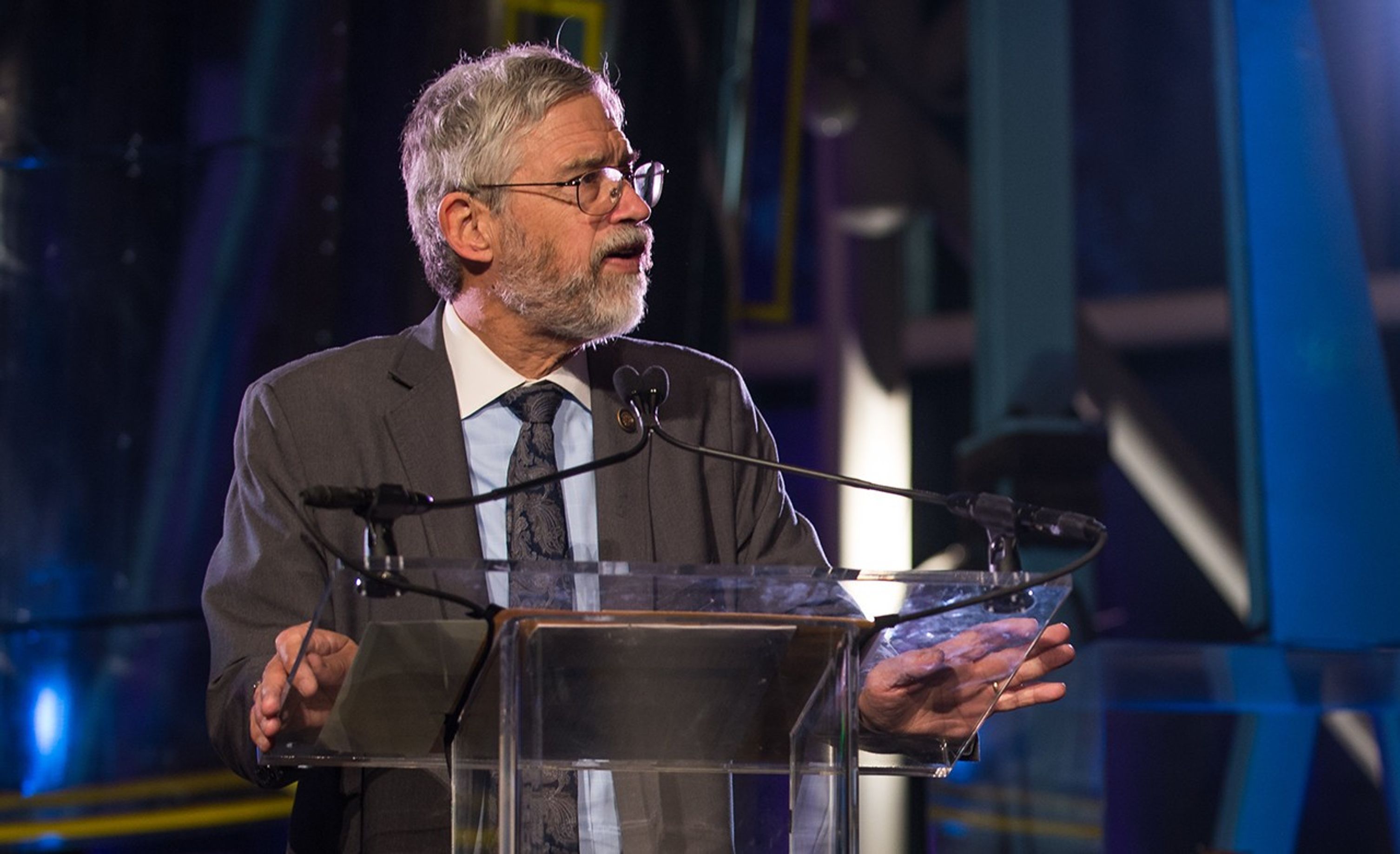 John Holdren stands at the podium, addressing the audience.