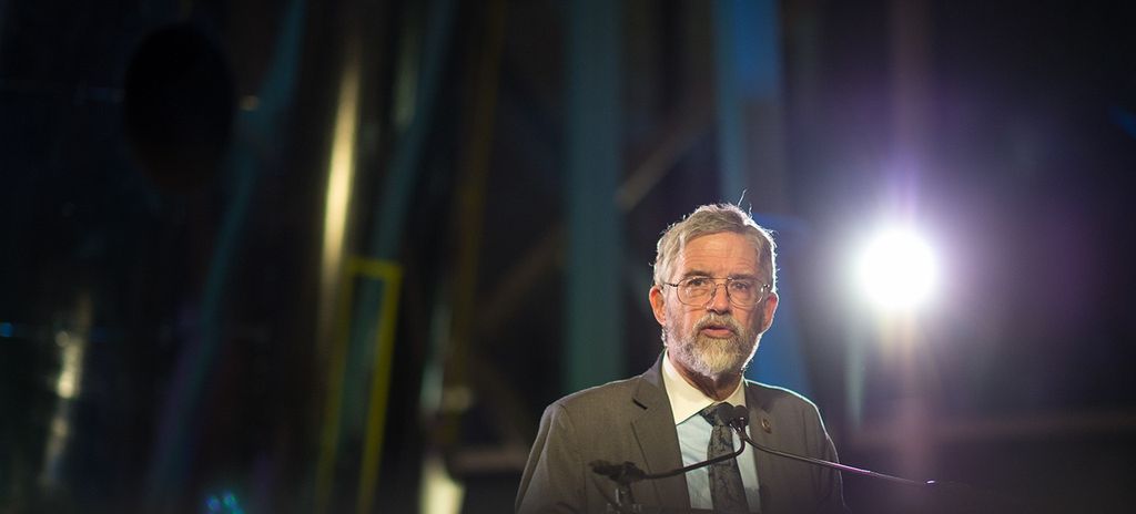 John Holdren stands at the podium, addressing the audience.