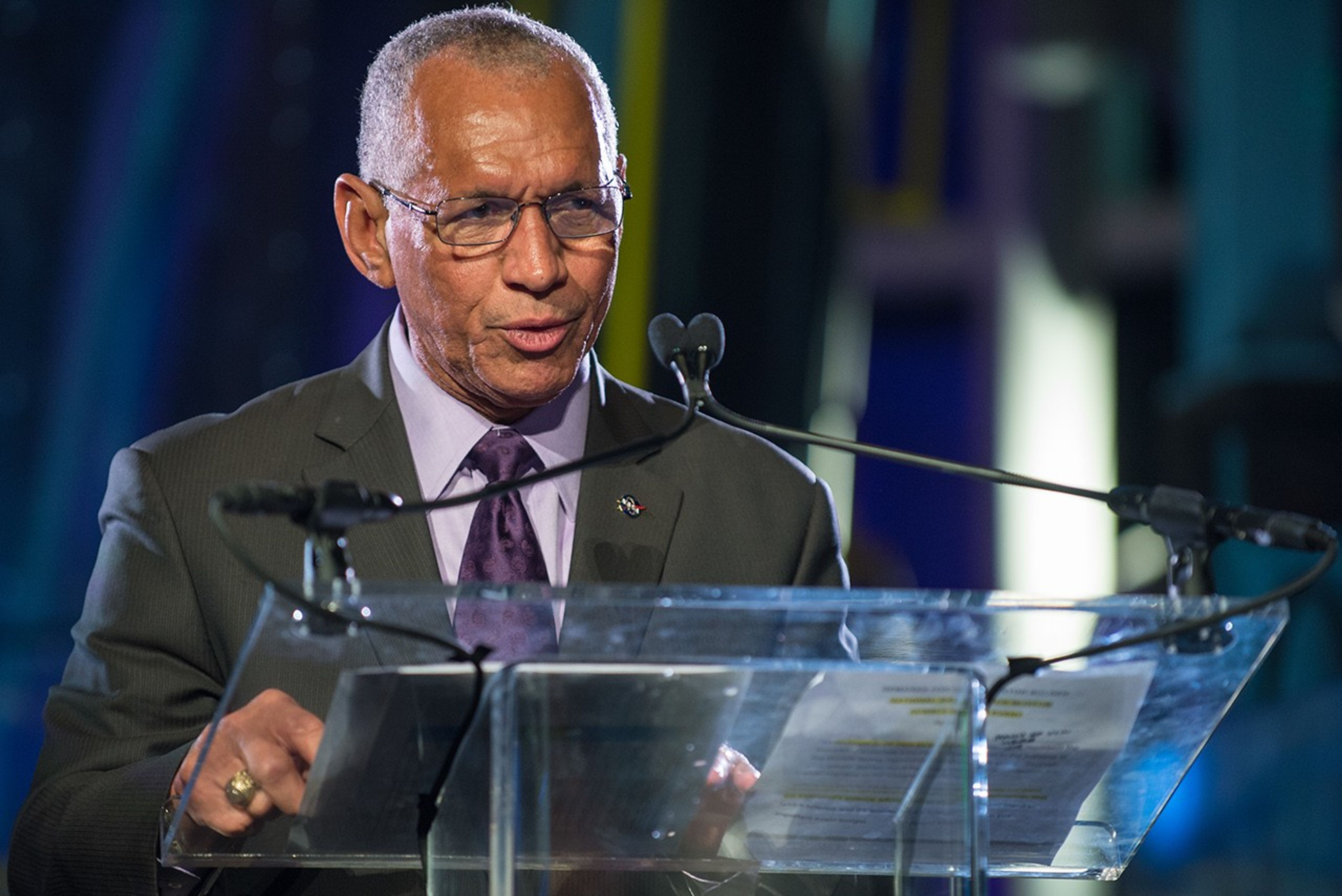 Charlie Bolden stands at the podium, addressing the audience.