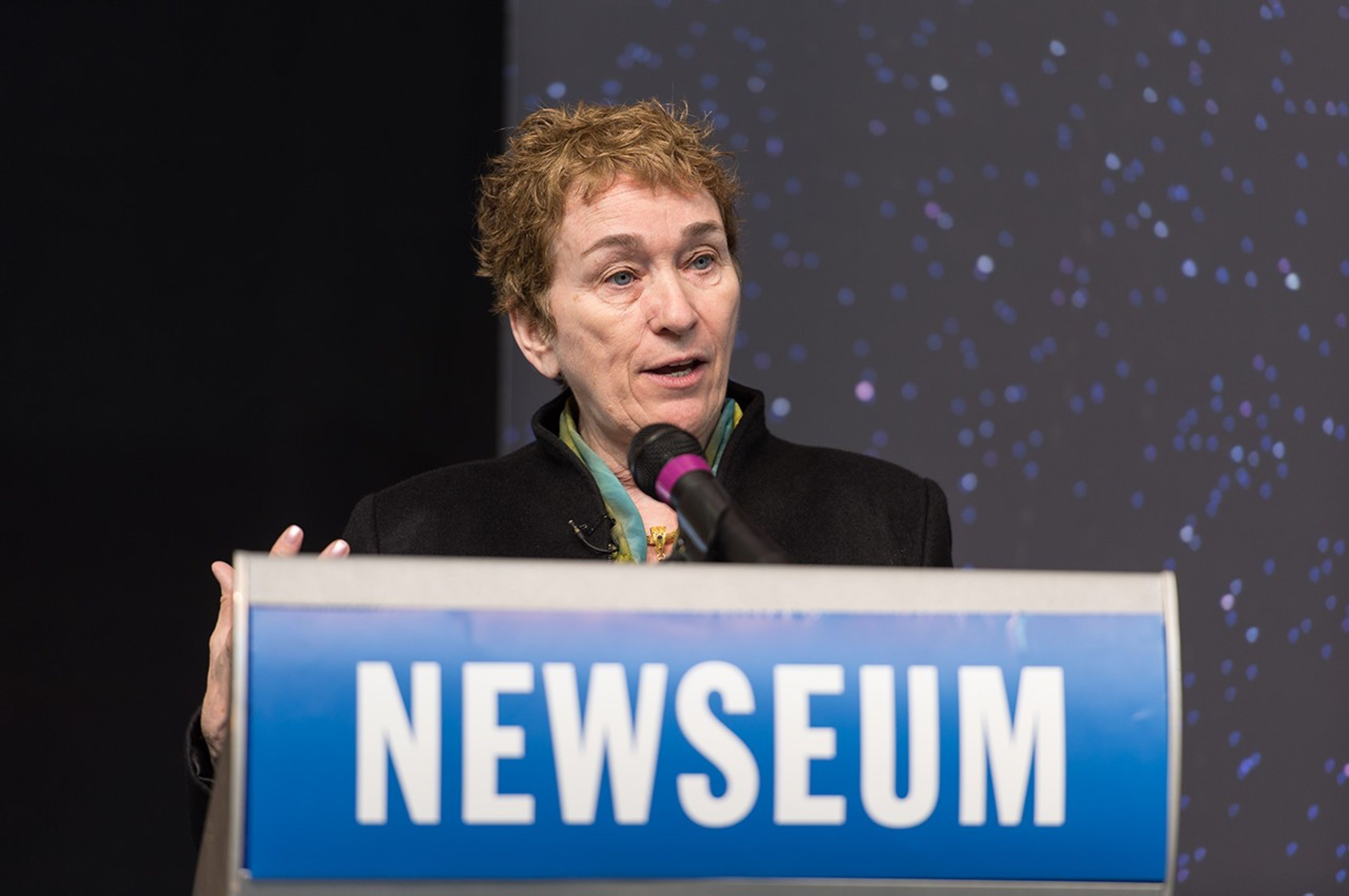 Dr. Kathryn Flanagan stands at the podium, addressing the audience.