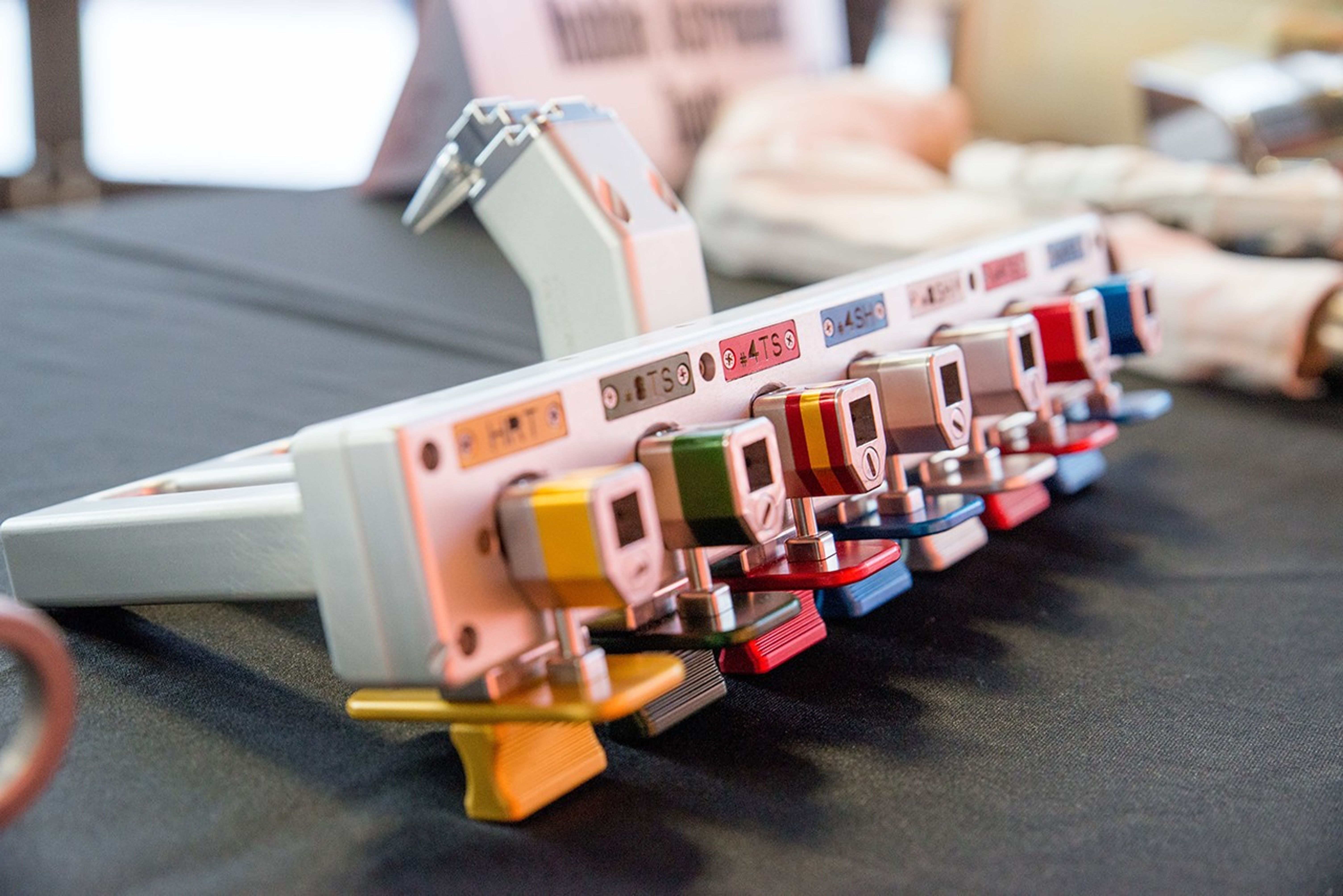 A silver bit caddy with seven bits for the mini power tool, with different colors on the end of each one.