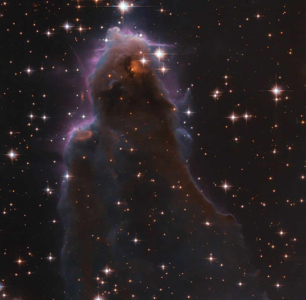 Whisp-like, purple-hued view of star-forming region against black backdrop of space.